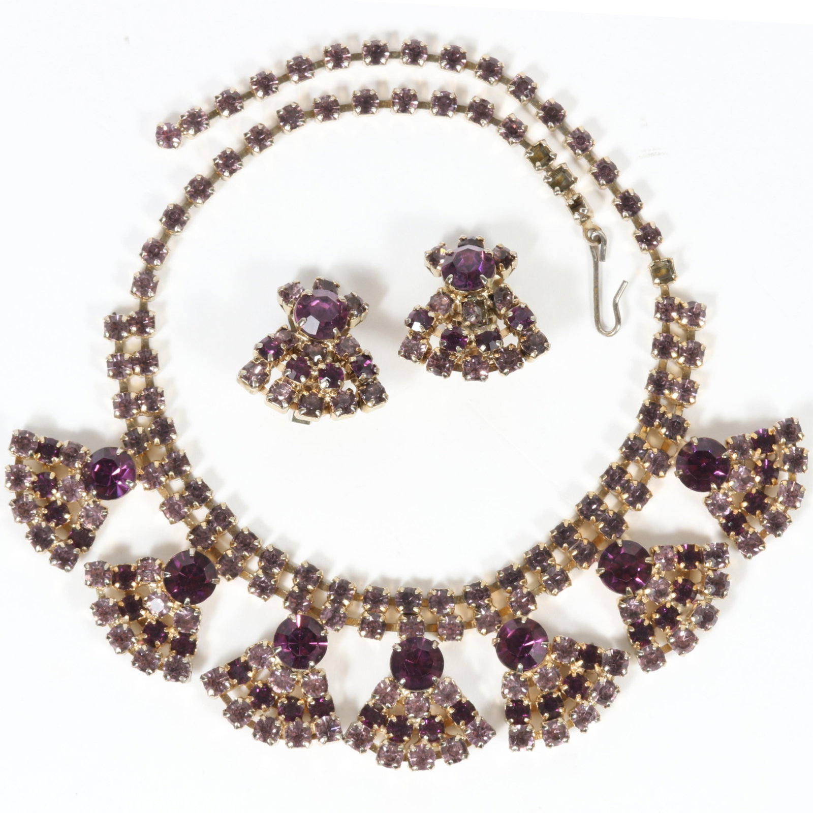 Vintage 1950's amethyst purple rhinestone spray necklace with matching earrings. 14" L x 1 1/4" Drop: Vintage 1950's amethyst purple rhinestone spray necklace with matching earrings. Some missing rhinestones on necklace. From the private collection of Leigh Leshner, author of 9 Costume Jewelry researc