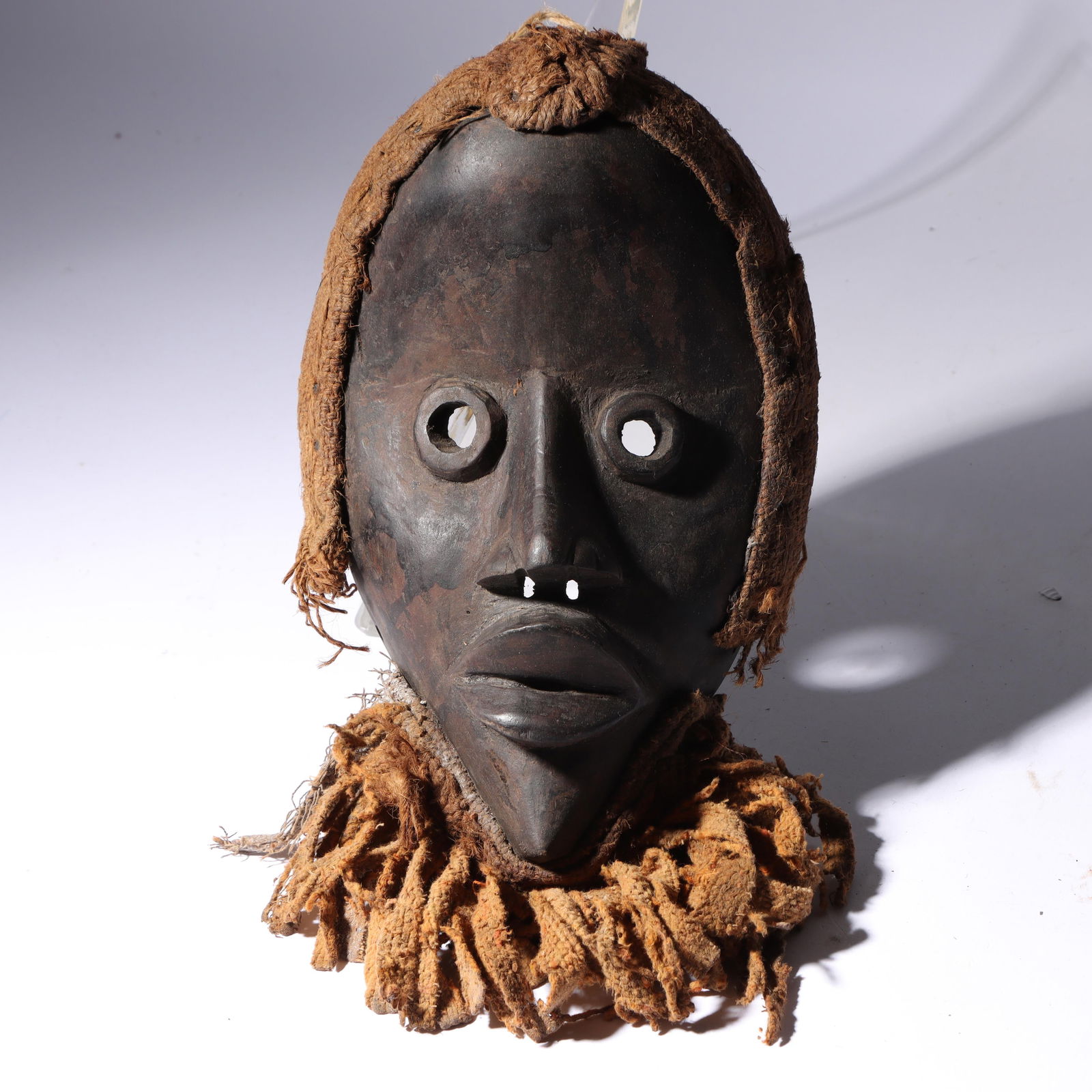 African carved wood tribal Dan mask with jute adornments. 15" x 7" x 4" (1 of 10)