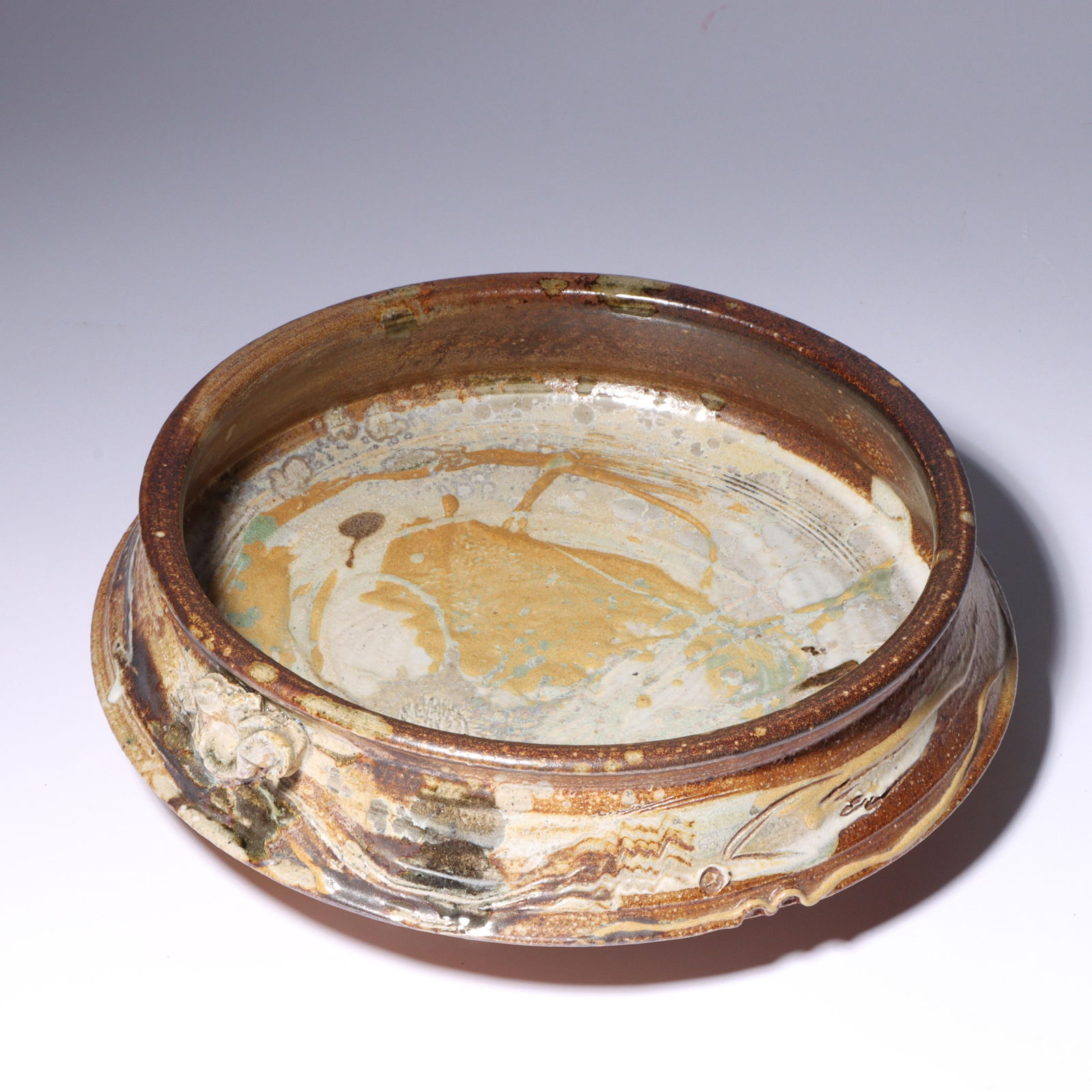 Don (Donald) Reitz, American (1929 - 2014), studio pottery vessel, glazed stoneware, 3"H x 10"Diam.: Don (Donald) Reitz American (1929 - 2014) studio pottery vessel glazed stoneware Incised signature under base. Biography from the Archives of askART: "Don Reitz: Clay, Fire, Salt, and Wood" by Jody Cl