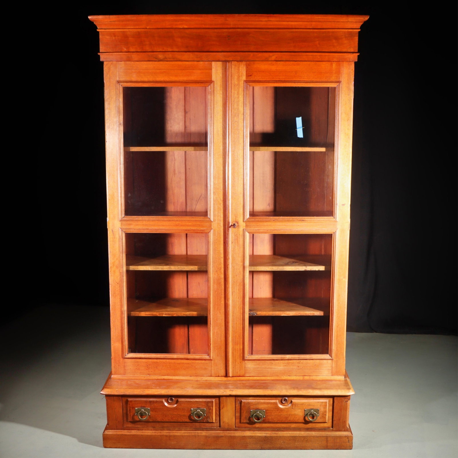 Antique American 19th century walnut bookcase with glass doors and two drawers below. 80"H x 50"W x (1 of 10)
