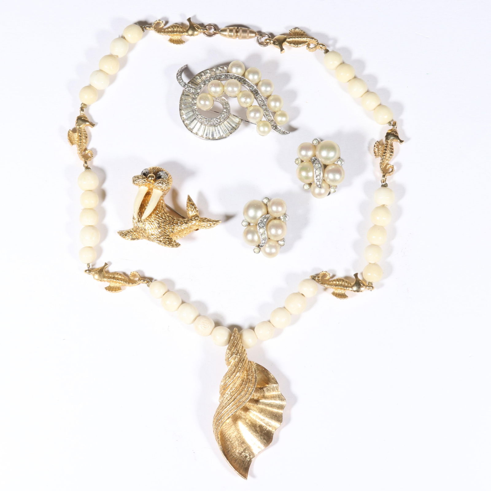 Jomaz and Mazer 4pc. jewelry group with Adolfo for Mazer shell beaded necklace, Jomaz figural walrus: Jomaz and Mazer 4pc. jewelry group with Adolfo for Mazer shell beaded necklace, Jomaz figural walrus brooch and Jomaz matching diamante rhinestone and faux pearl brooch and earrings. Provenance: From