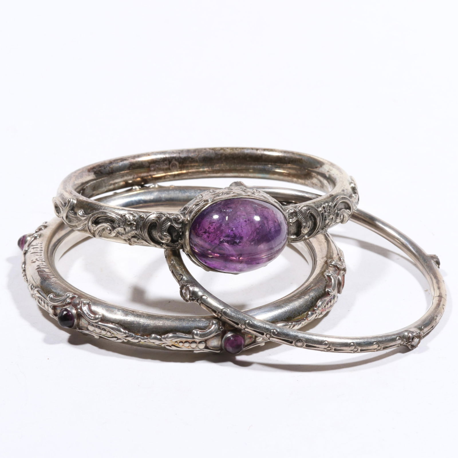 Victorian bracelets with pair of sterling amethyst cabochon bangles, and sterling? rose quartz: Victorian bracelets with pair of sterling amethyst cabochon bangles, and sterling? rose quartz bangle bracelet. Some tarnishing to all. Friendship bangle reads "Val to Edith" has one missing stone and