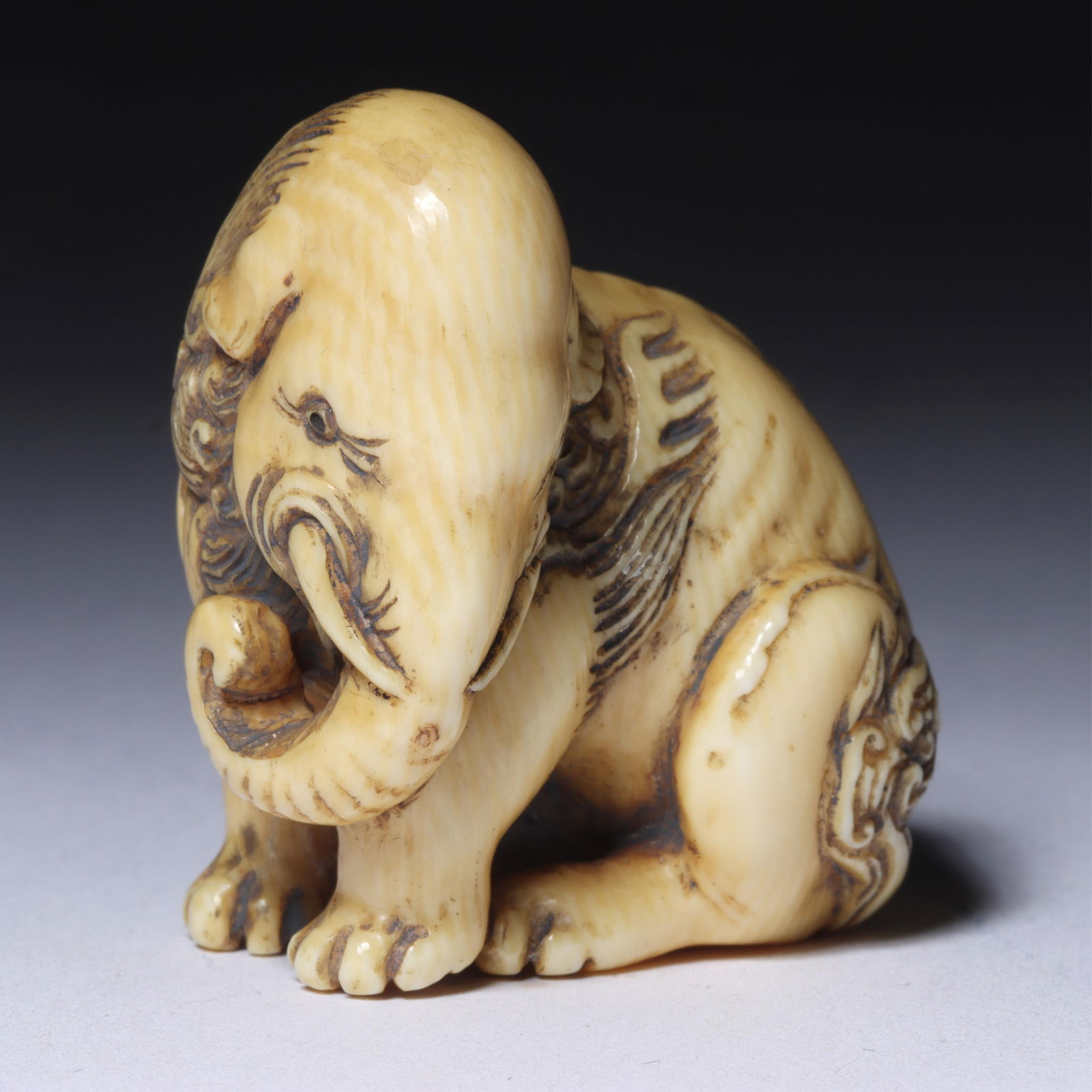 Japanese carved guardian animal figure netsuke; elephant/lion mythical beast in seated position, (1 of 7)