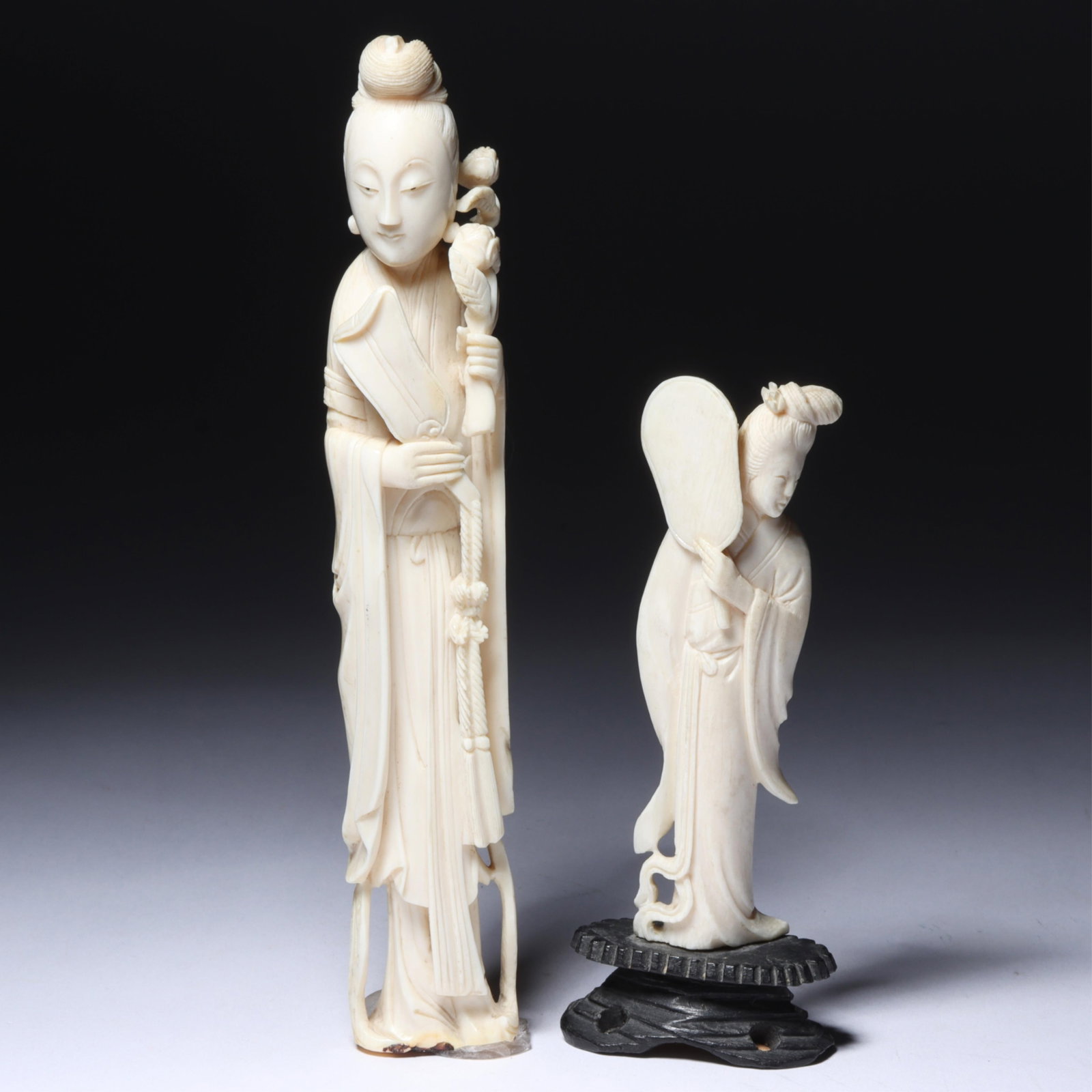 Japanese carved Guanyin deity okimono figure 2pc group: standing Guanyin holding a fan with a long: Japanese carved Guanyin deity okimono figure 2pc group: standing Guanyin holding a fan with a long robe; standing Guanyin holding a flower. 7"H x 1 1/4"W - largest