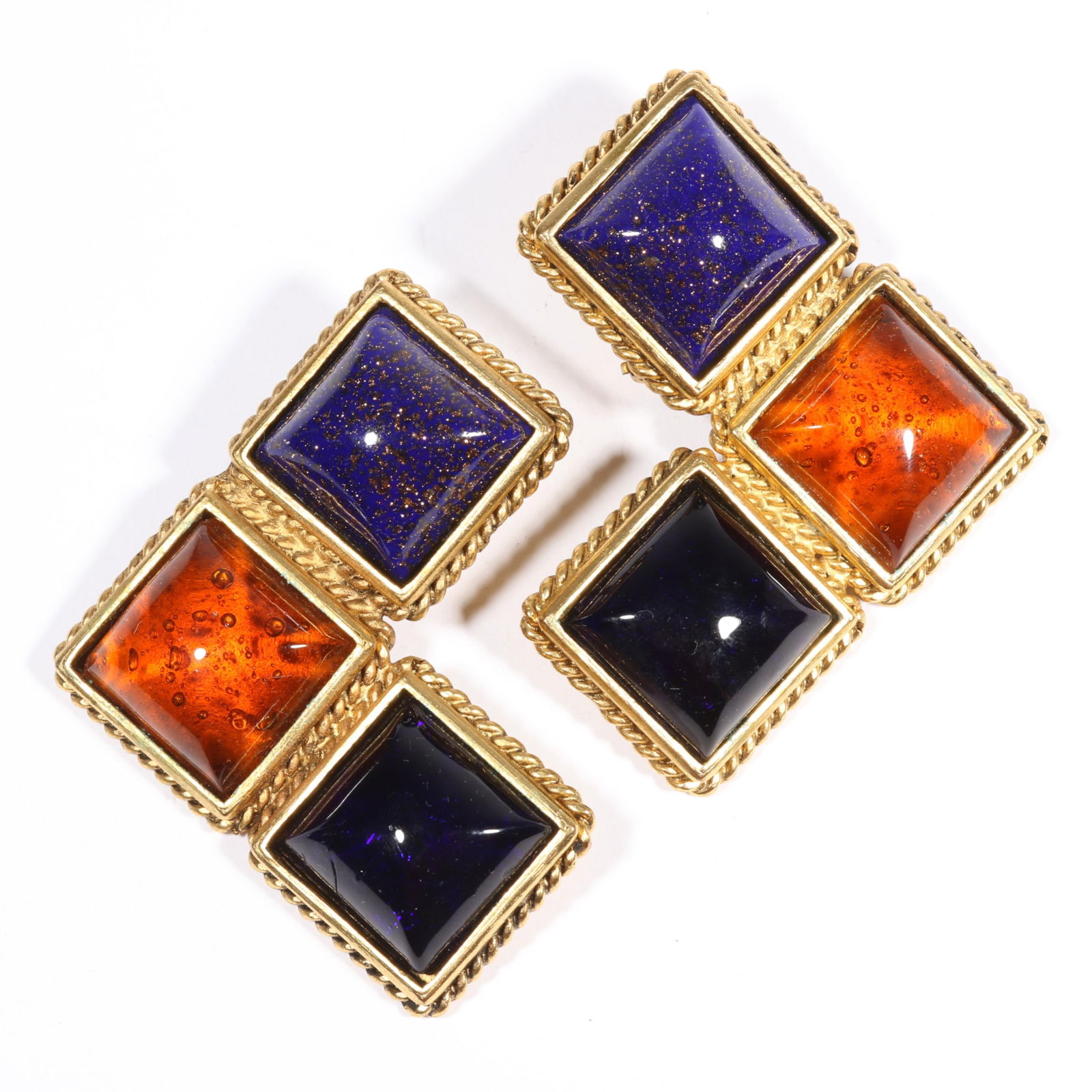 Isabel Canovas designer earrings comprised of gilt metal "metal dore" and featuring an ornate: Isabel Canovas designer earrings comprised of gilt metal "metal dore" and featuring an ornate pattern that is accented by three "pate de verre" poured glass cabochons in navy blue, orange, and purple,