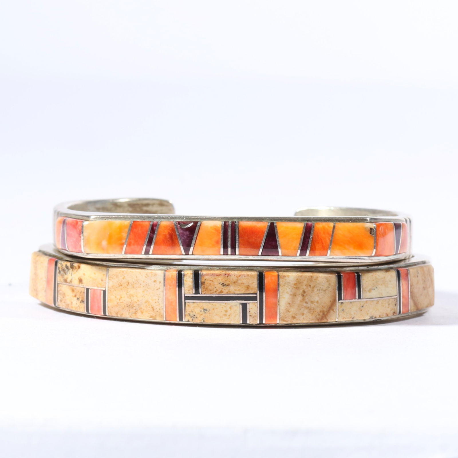 Pair of Native American sterling silver cuff bracelets with natural stone and spiny oyster shell: Pair of Native American sterling silver cuff bracelets with natural stone and spiny oyster shell inlay.Provenance: From the Estate of Rita B. Grunwald3/8"H x 2 1/4"W x 7/8"Gap (largest bracelet)