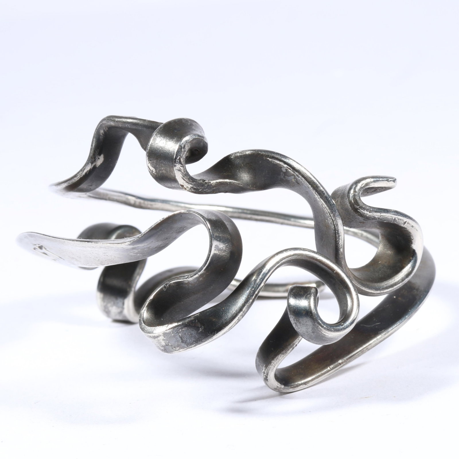 Jerald Jacquard massive metalsmith, studio art hand forged bracelet with wide, twisting ribbons of: Jerald Jacquard massive metalsmith, studio art hand forged bracelet with wide, twisting ribbons of 800 silver, stamped with inscription "ART IS LIFE".Provenance: From the Estate of Rita B. Grunwald 3.