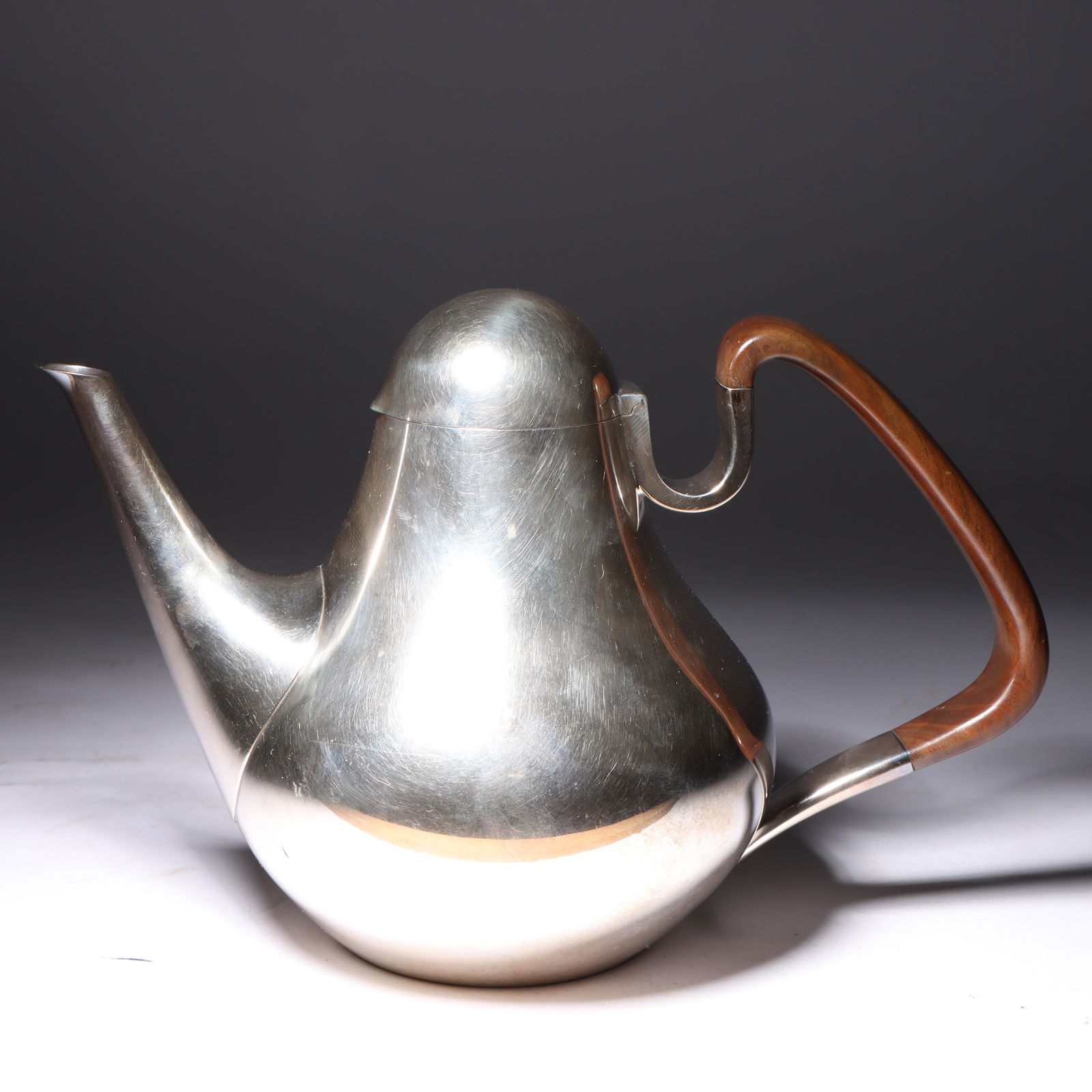1950's Henning Koppel for Georg Jensen Danish modern sterling silver and ebony teapot, No. 1017. 6: 1950's Henning Koppel for Georg Jensen Danish modern sterling silver and ebony teapot, No. 1017.Provenance: From the Estate of Rita B. Grunwald 23.3333 troy oz6 1/4"H x 9 1/2"W