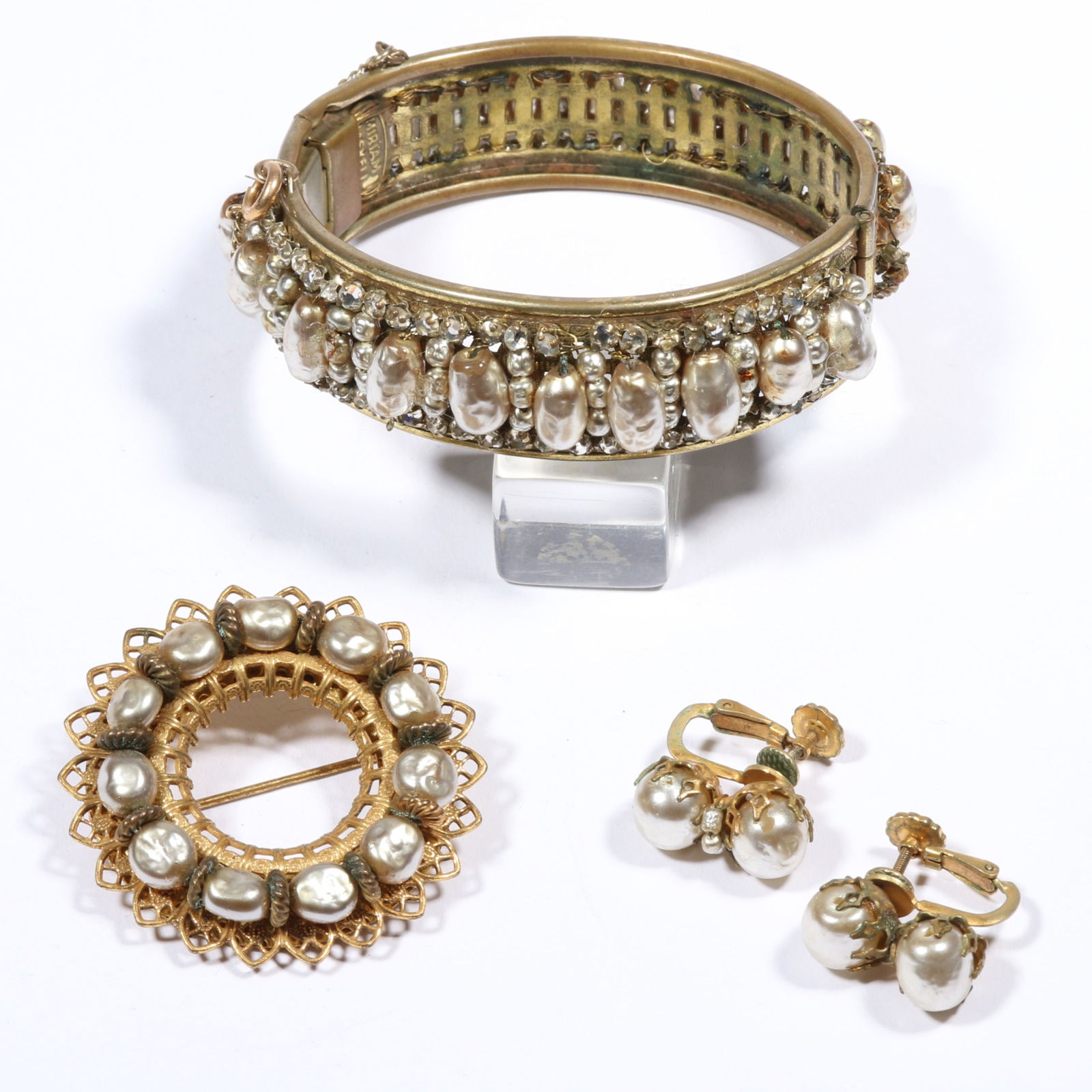 Miriam Haskell faux pearl jewelry group including large hinged bangle bracelet, brooch, and: Miriam Haskell faux pearl jewelry group including large hinged bangle bracelet, brooch, and earrings Bracelet is very fragile and has some pearls falling off and has loss of pearl coating. 7/8"H x 2 1