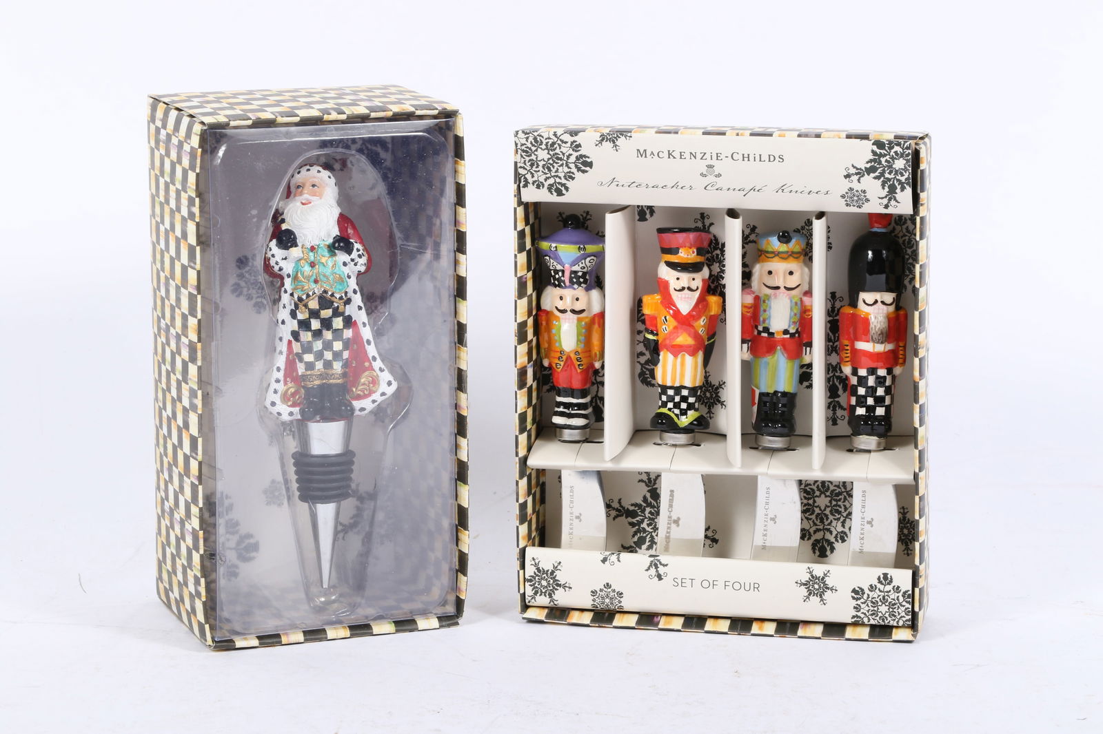 MacKenzie-Childs Nutcracker Canap?© knife set and Santa Claus bottle stopper 7'H x 5 3/4'W (knife: MacKenzie-Childs Nutcracker Canap?© knife set and Santa Claus bottle stopper A set of four MacKenzie-Childs Nutcracker-themed canap?© knives and a wine bottle stopper. The knives feature colorful, h