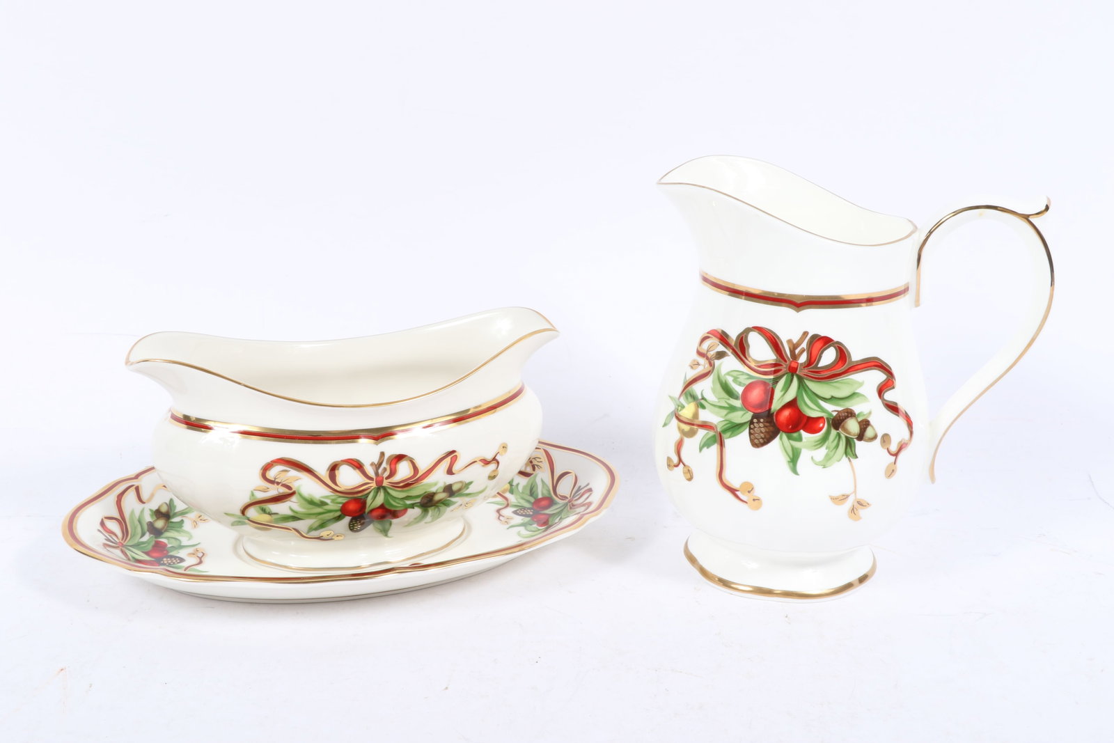 Tiffany Holiday Christmas pitcher and gravy boat with underplate 6 3/4'H x 4 1/4'Diam. (pitcher): Tiffany Holiday Christmas pitcher and gravy boat with underplate A Tiffany & Co. holiday-themed pitcher and a gravy boat with an underplate featuring a festive design with red and green accents, holly