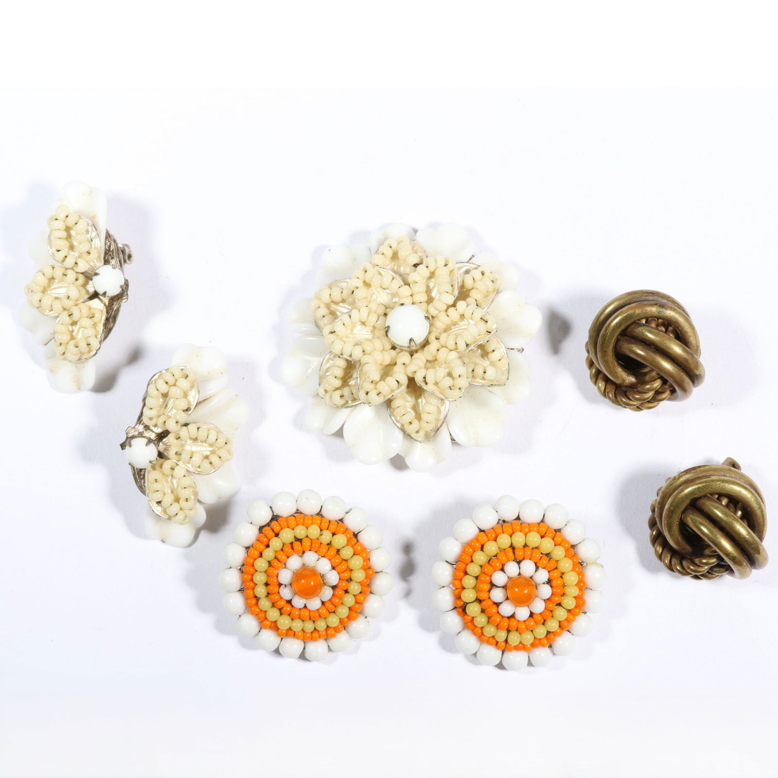 Miriam Haskell jewelry group including milk glass floral brooch and matching earrings, orange and: Miriam Haskell jewelry group including milk glass floral brooch and matching earrings, orange and white beaded earrings, and gilt knot beaded earrings. 2 1/8"Diameter (brooch)