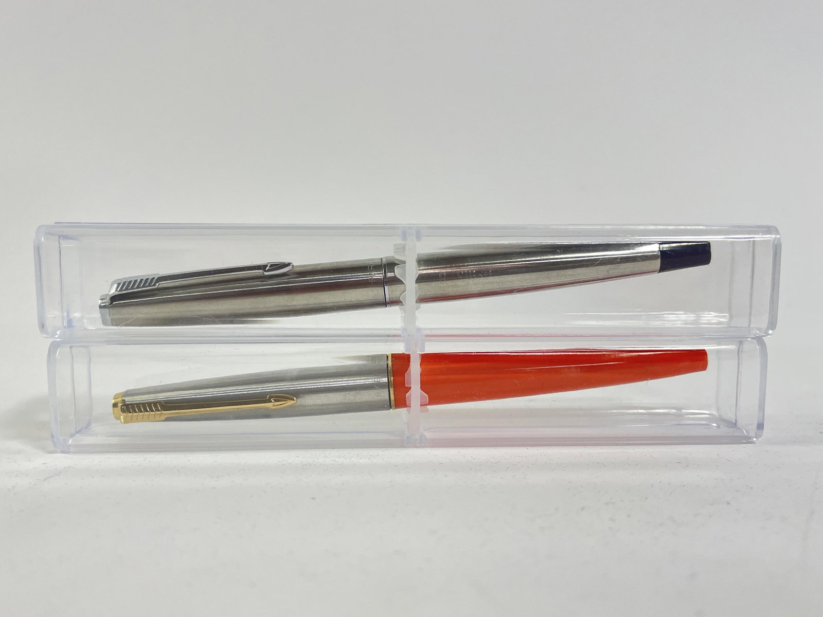 Pair of Parker Pens: Pair of Parker Pens Parker 45 with Orange body, Parker silver pen with H. Elliot engraved on the side, both in plastic cases