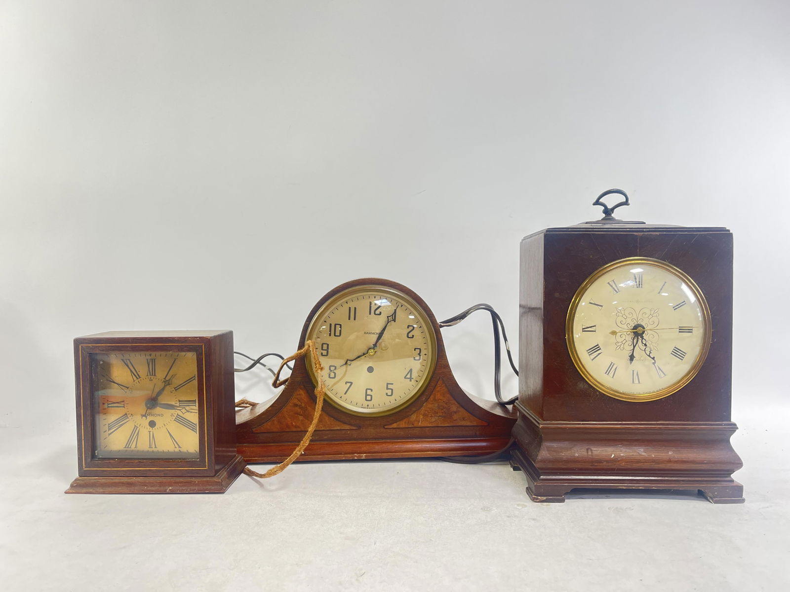 Group of Three Desk/Mantel Clocks, Untested: Group of Three Desk/Mantel Clocks, Untested Three untested clocks, two Hammond mantle clocks, General Electric Strikes clock with handle on top, tallest clock: 12" H X 7" W X 4" D