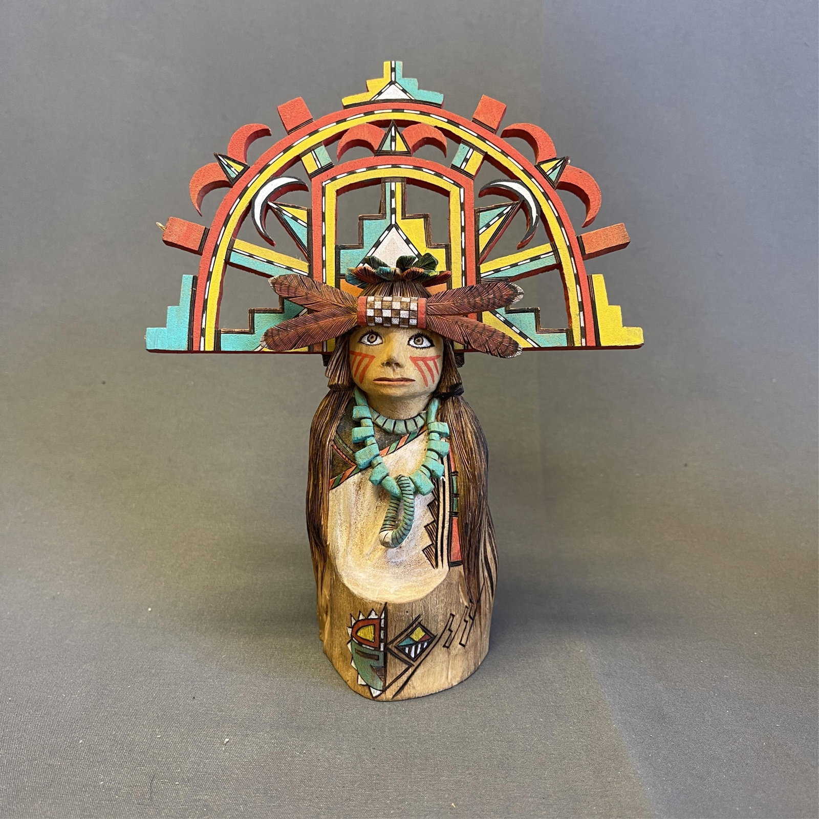 Pahlik Mana (Corn Grinding Girl), carved and painted Hopi doll 5 1/2 high x 6 1/2" wide at widest: Pahlik Mana (Corn Grinding Girl) Hopi Pahlik Mana or Corn Grinding Girl is wearing an elaborate tablita (headdress) and a beautiful turquoise necklace. The Palhik Mana is not a kachina but has the dut