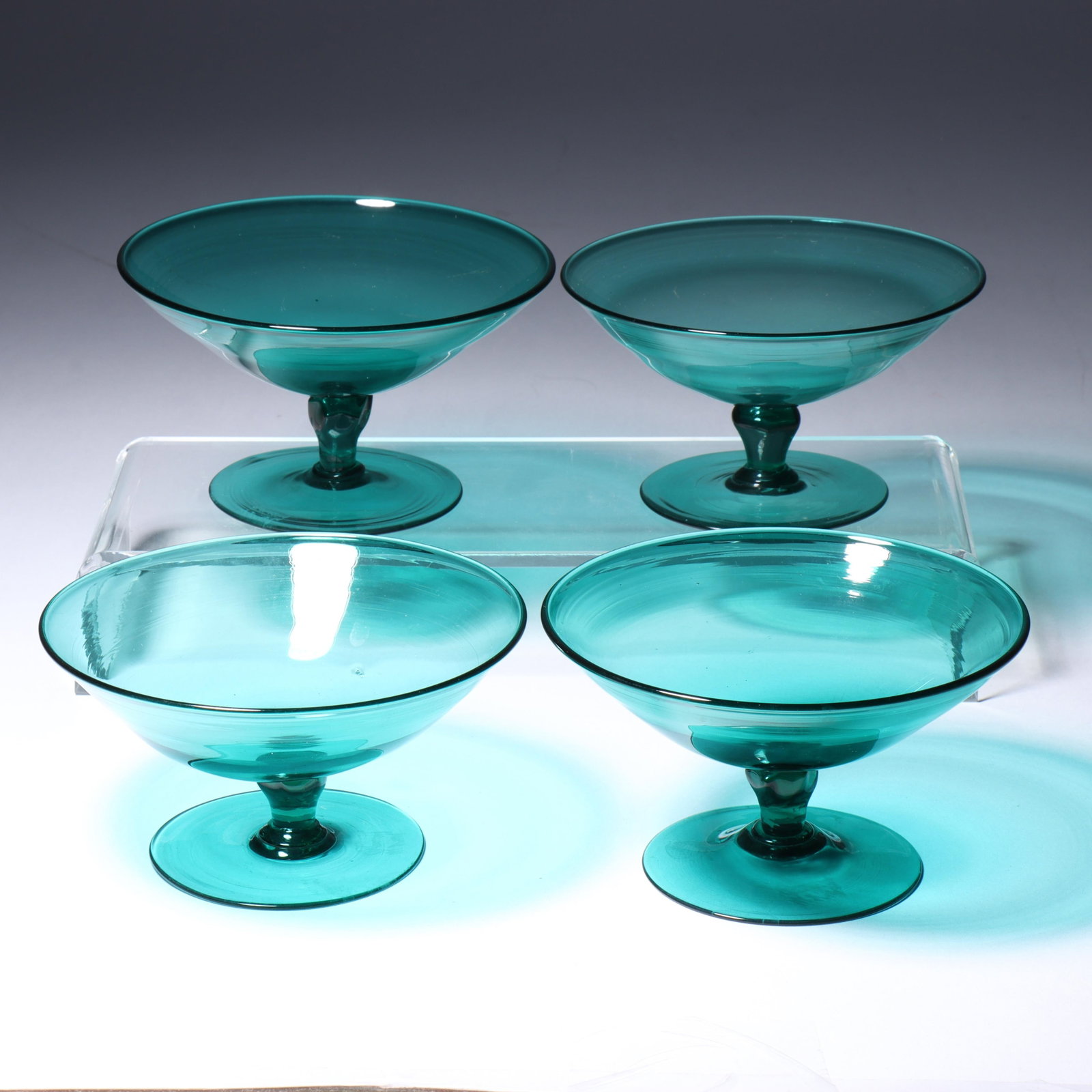 Four Maestri Vetrai Muranesi (MVM) Murano Cappellin stemmed bowls in dark teal 2 1/4"H x 3 3/4"Diam.: Four Maestri Vetrai Muranesi (MVM) Murano Cappellin stemmed bowls in dark teal Acid stamps present on all. Provenance: Fort Wayne Museum of Art, Fort Wayne, Indiana. 2 1/4"H x 3 3/4"Diam. (one)