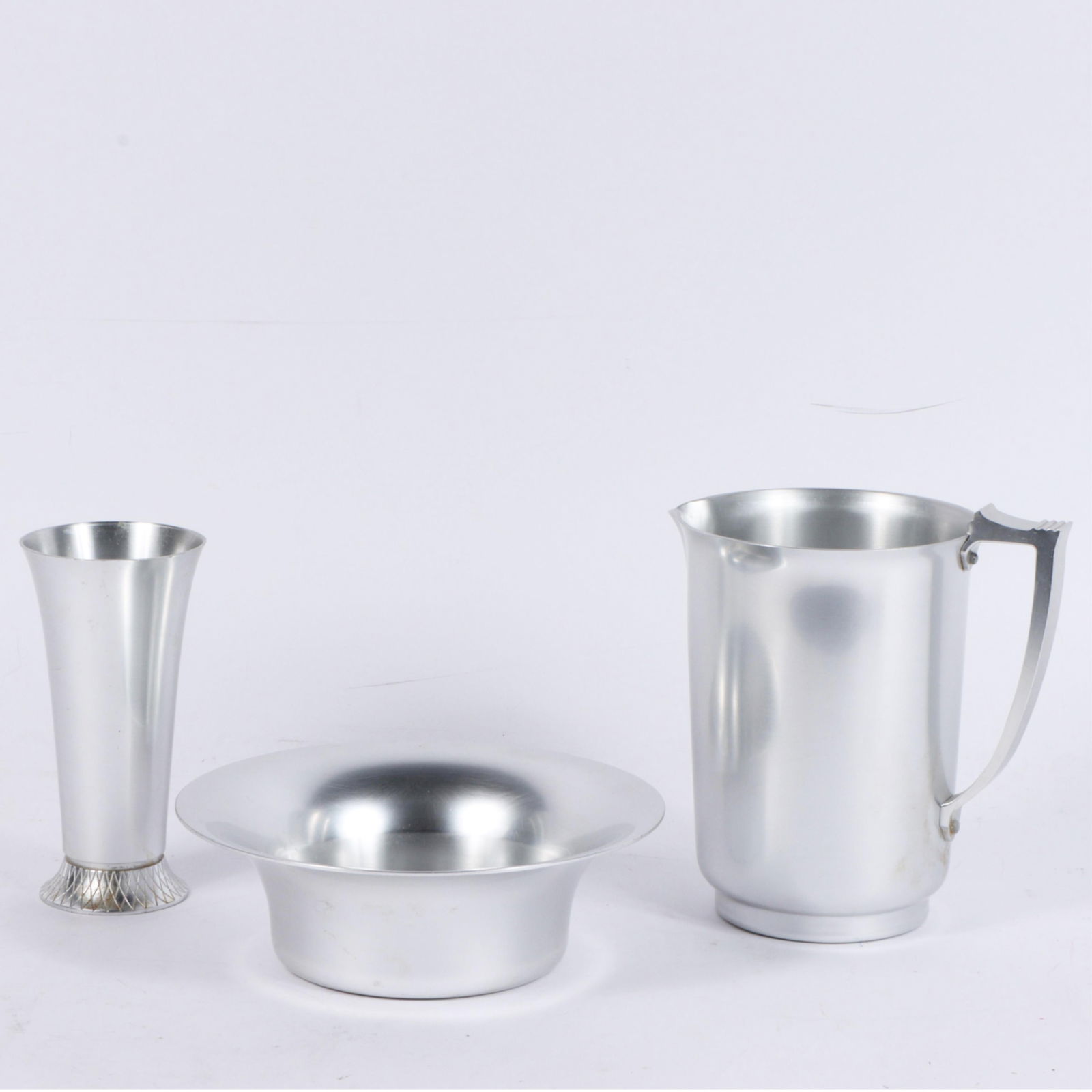 Lurelle Guild Kensington Aluminum Pitcher, Bowl & Vase 8 1/4"H x 5 3/4"Diam. (Largest): Lurelle Guild Kensington Aluminum Pitcher, Bowl & Vase #7231 "Mayfair" Pitcher, 1935; #7410 "Wiltshire" bowl (retail 4.00); #7032 "KIngston" vase (retail 5.00) Provenance: Charles Alexander, Indianapo