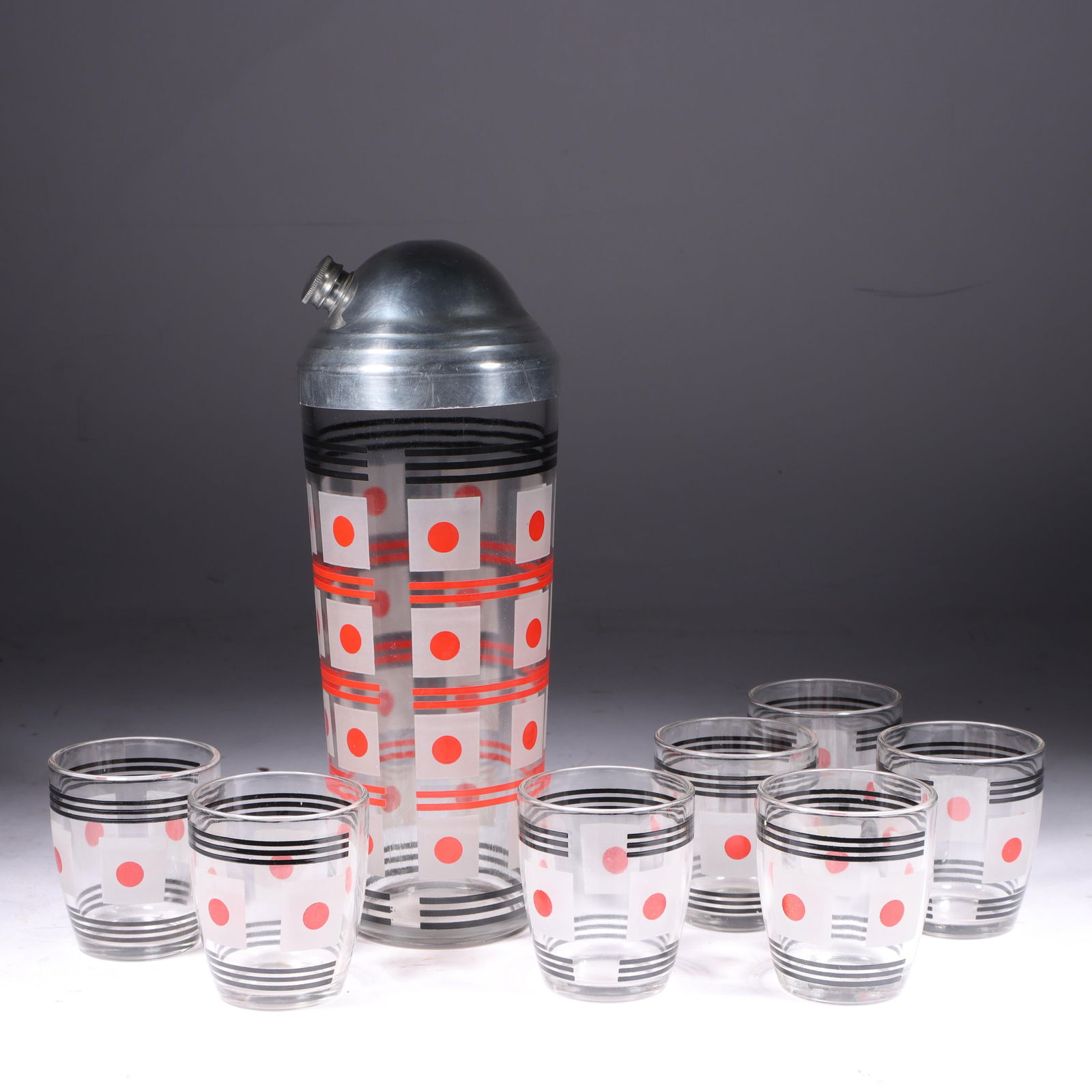 Art Deco Aluminum & Glass Cocktail Set-7 pcs. 10 1/4"H x 3 3/4"Diam. (shaker): Art Deco Aluminum & Glass Cocktail Set-7 pcs. Enameled red, black, and white glass with an aluminum lid. Provenance: Charles Alexander, Indianapolis, IN 10 1/4"H x 3 3/4"Diam. (shaker)