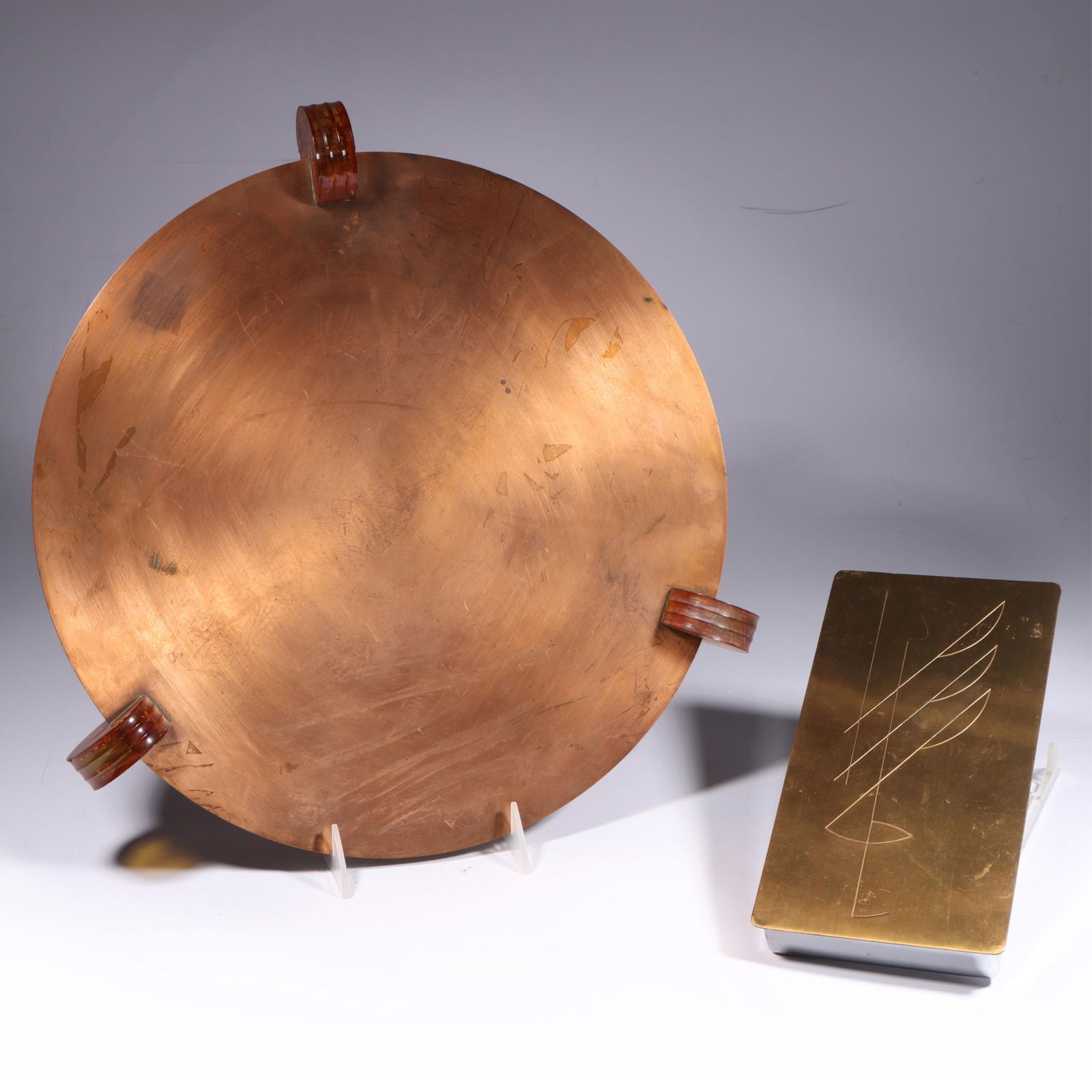 Art Deco Copper/Lucite Tray w/ Revere Brass Cigarette Box 14"Diam. (tray): Art Deco Copper/Lucite Tray w/ Revere Brass Cigarette Box Polished copper tray with three Lucite handles; Norman Bel Geddes Revere Copper & Brass Co. Cigarette Box w wooden Interior marked: "Revere, R