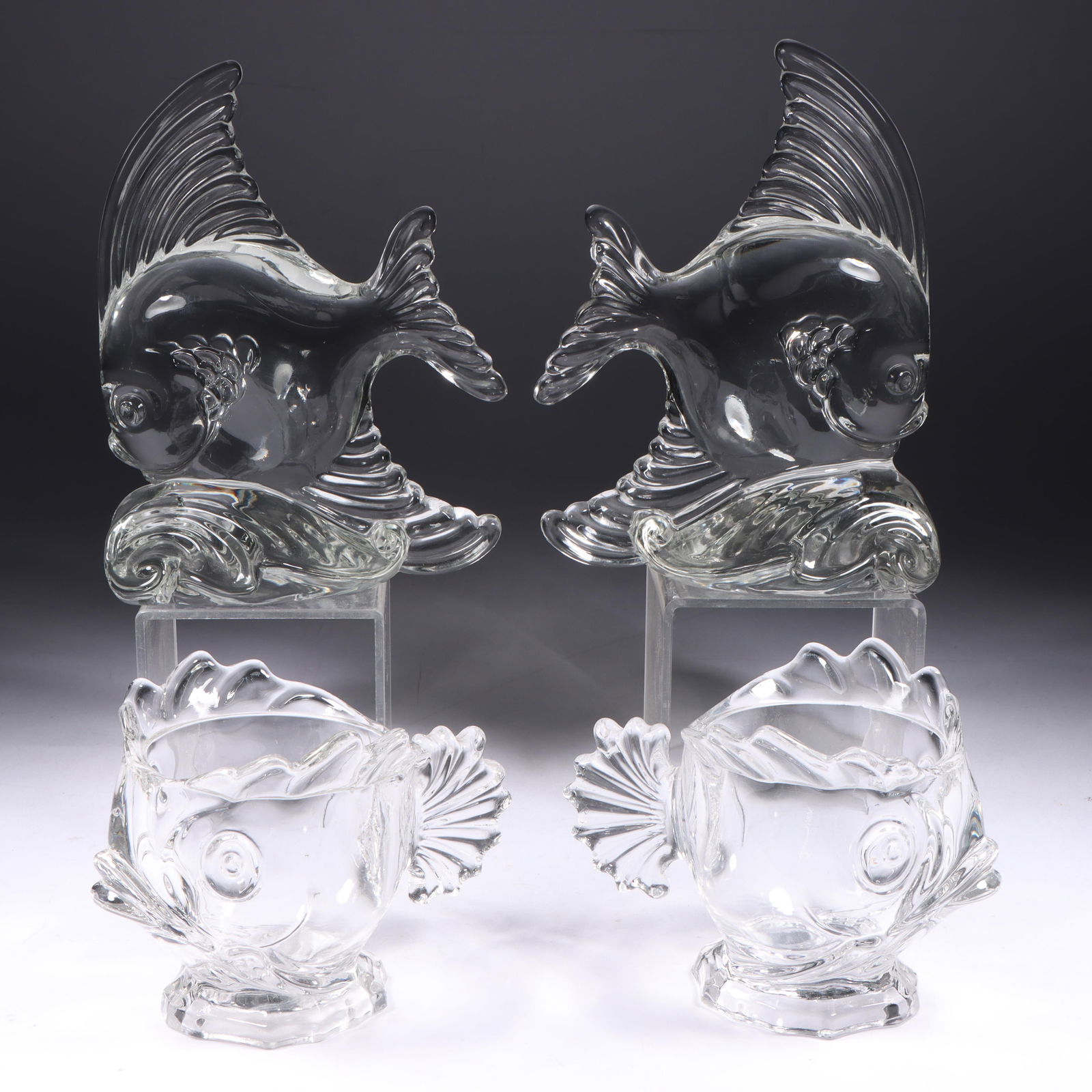 Heisey Pair of Fish Bookends & Fostoria Seafood/Cocktail Cups 6 1/2"H (one): Heisey Pair of Fish Bookends & Fostoria Seafood/Cocktail Cups Heisey glass Bookends designed by Royal Hickman. Provenance: Charles Alexander, Indianapolis, IN 6 1/2"H (one)