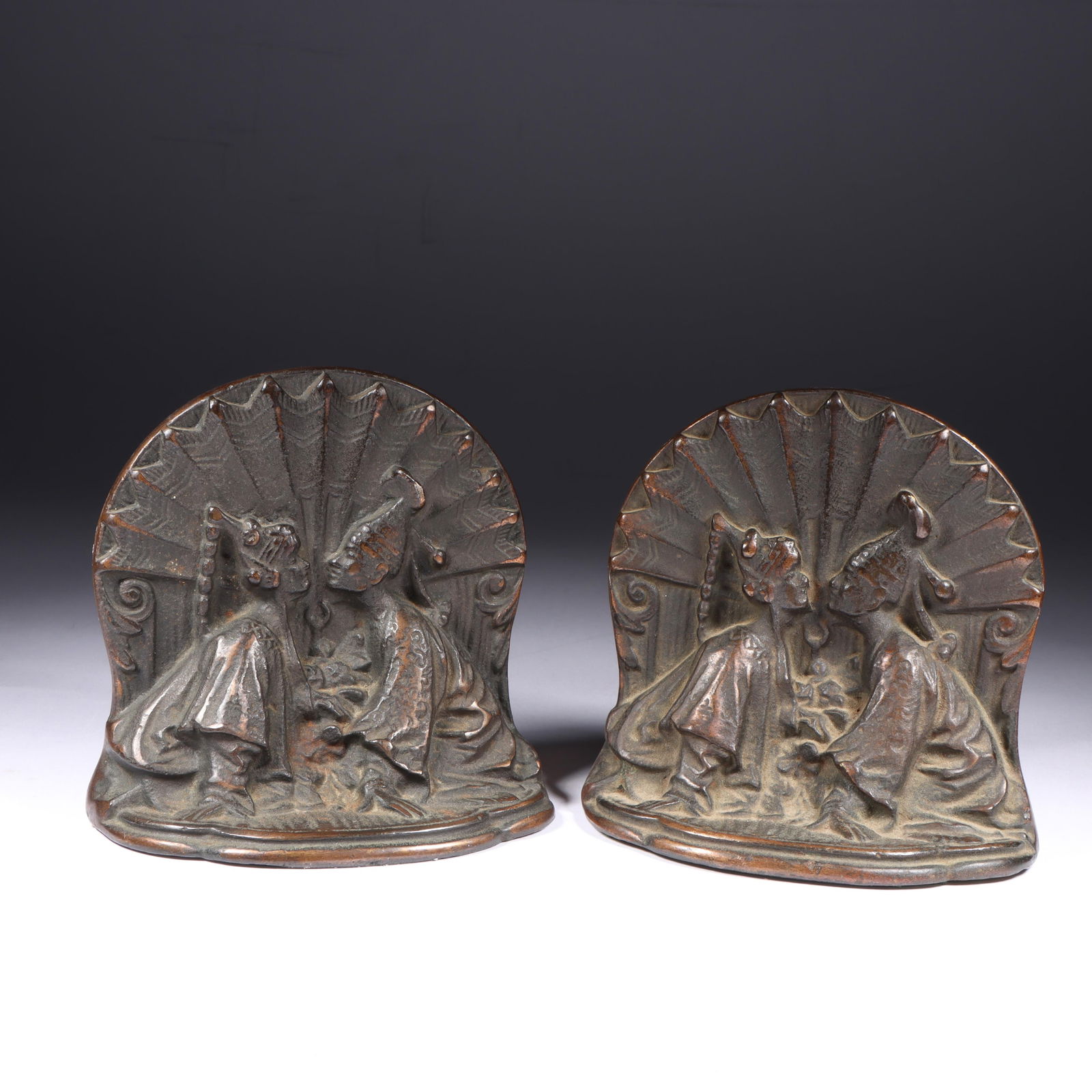 Pair of Iron Chinese Motif Bookends 4 3/4"H x 4 3/4"W (one end): Pair of Iron Chinese Motif Bookends Chinese couple in front of stylized Art Deco fan motif. Provenance: Charles Alexander, Indianapolis, IN 4 3/4"H x 4 3/4"W (one end)