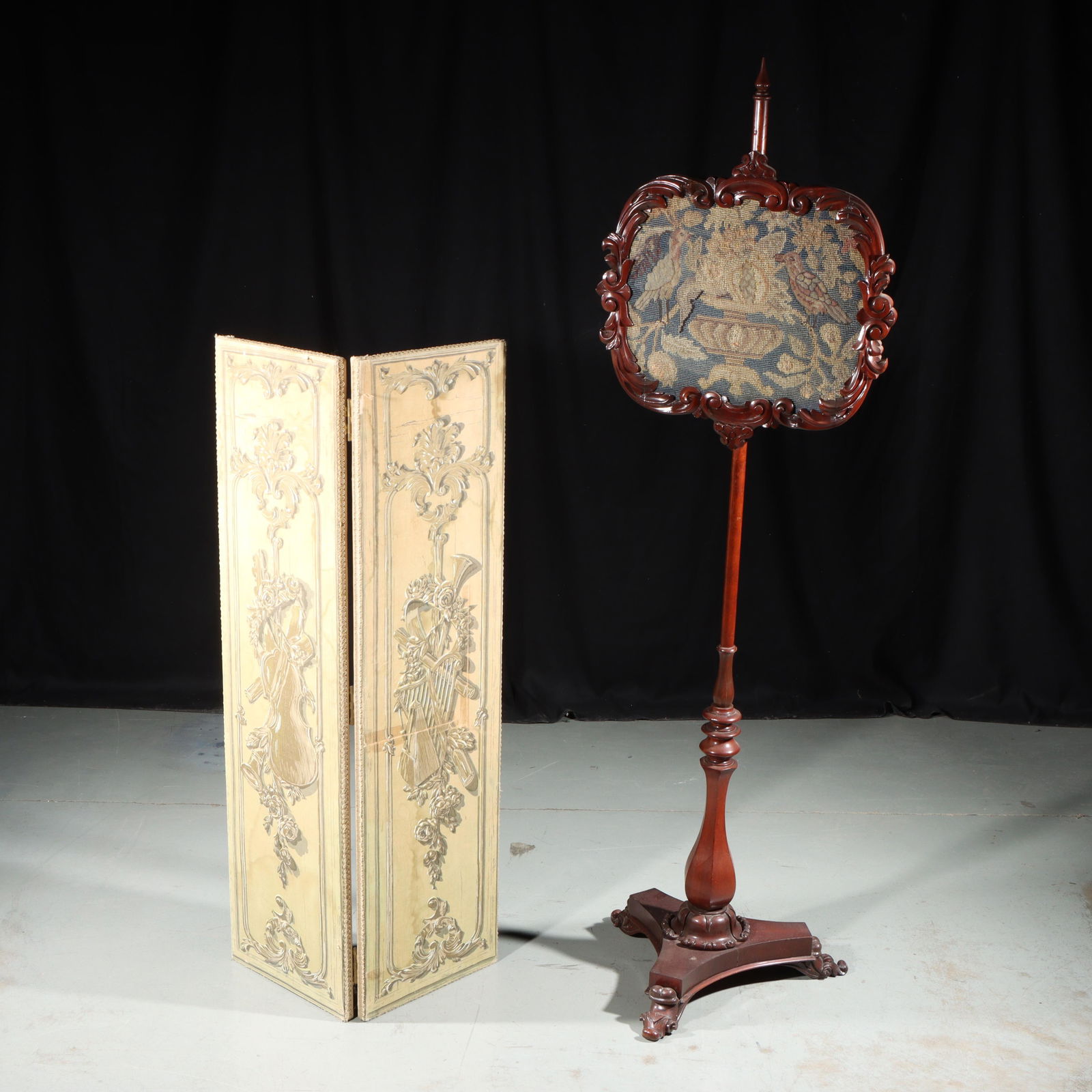 Victorian carved mahogany fireside pole screen with needle point panel featuring birds perched on an: Victorian carved mahogany fireside pole screen with needle point panel featuring birds perched on an planter and antique 2 panel folding screen covered with fabric featuring musical instruments and ro