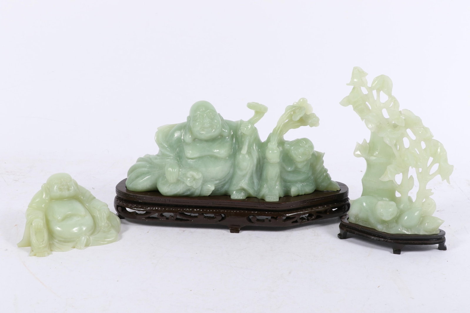 Chinese carved jade figure statues, 3pc: seated laughing Buddha, tree with cat 4 1/2"H x 9 1/2"W x 2: Chinese carved jade figure statues, 3pc: seated laughing Buddha, tree with cat Two with wooden display stands 4 1/2"H x 9 1/2"W x 2 1/2"D (Largest)