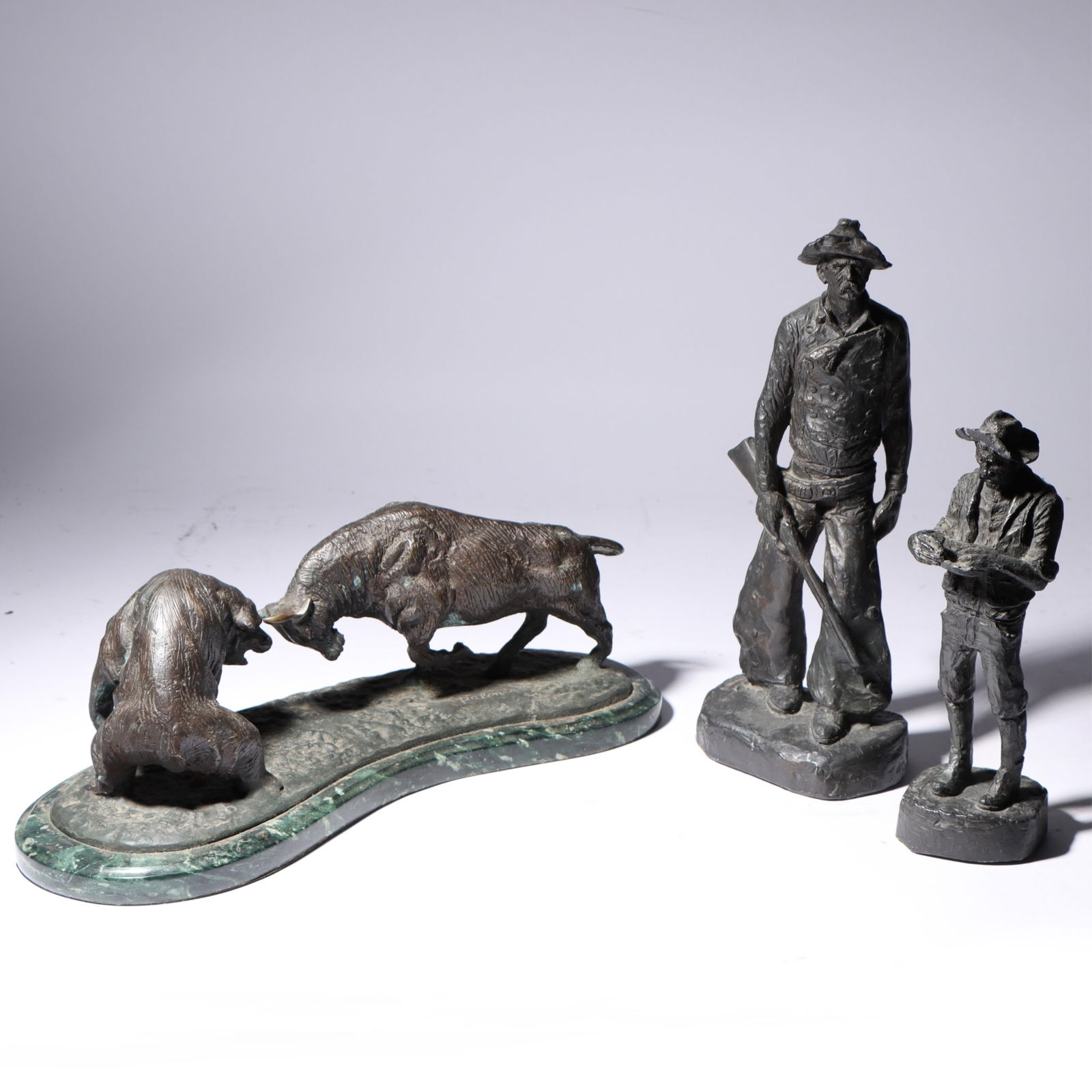 Three figural sculptures: 2 Michael Garman Productions Western / Early American cowboy figure: Three figural sculptures: 2 Michael Garman Productions Western / Early American cowboy figure sculptures; Paloma "bull versus bear" Wall Street bronze sculpture with green marble base, 2004 State Farm