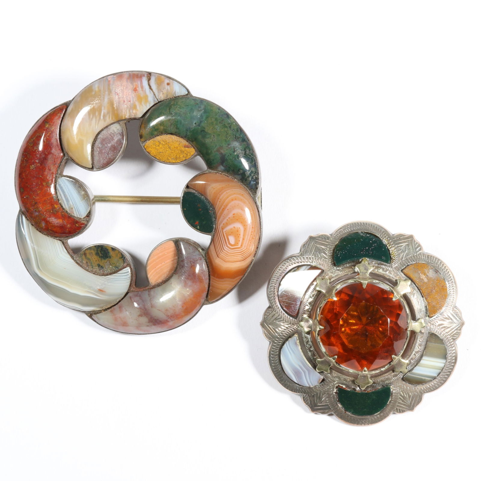 Pair of Antique Scottish agate unmarked sterling? brooches. 2 1/4"Diameter (larger brooch): Pair of Antique Scottish agate unmarked sterling? brooches. One cracked stone and one chipped on larger brooch. Provenance: From the collection of Sue Rudman, owner of Antique Source, Ltd in NYC for m