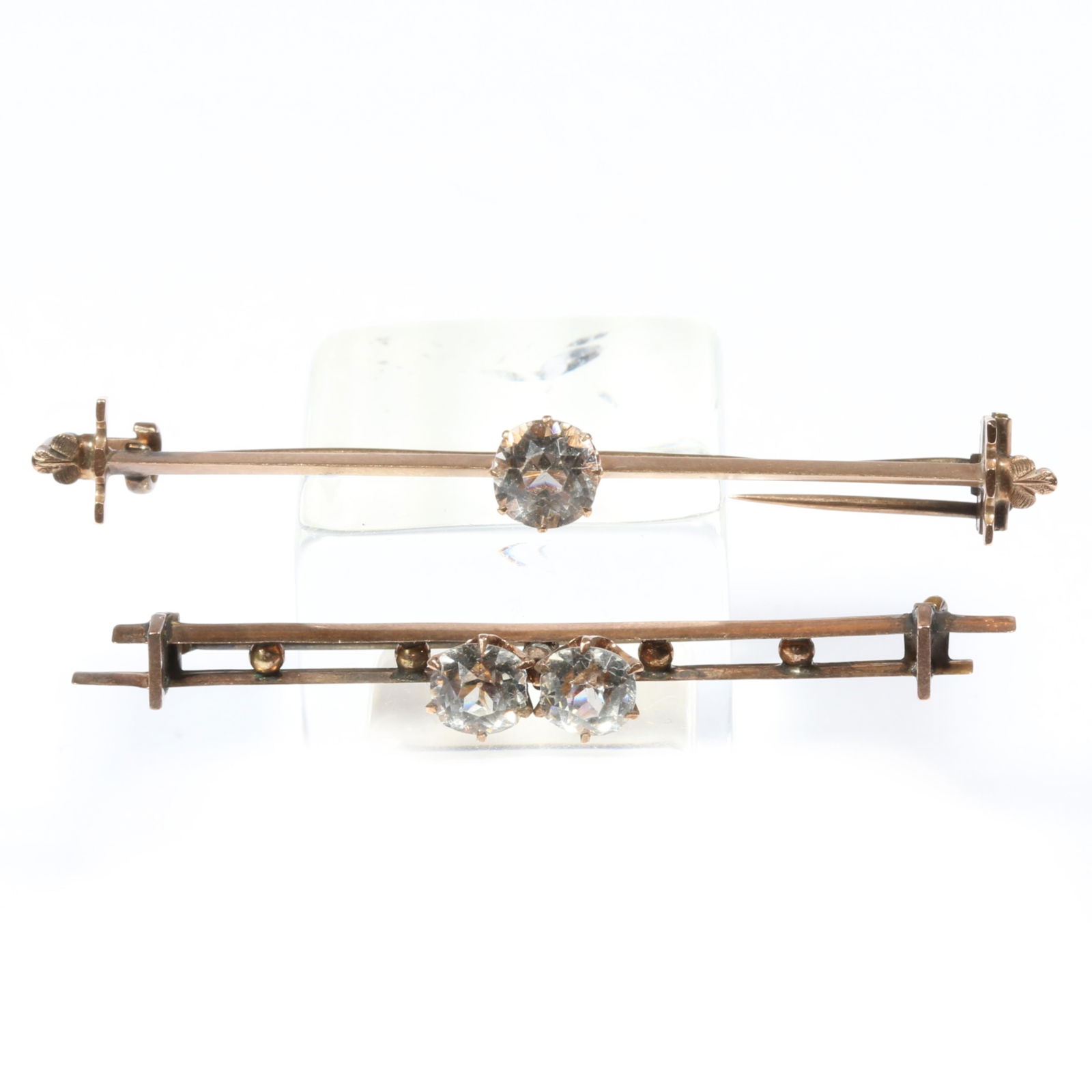 14K Victorian unmarked tested paste stone bar brooches. 2 1/4"W x 1/4"H (bigger brooch): 14K Victorian unmarked tested paste stone bar brooches. 1.80DWT (single paste brooch) 1.85DWT (double paste brooch) The purchase of gold requires confirmed funds. Provenance: From the collection of Su