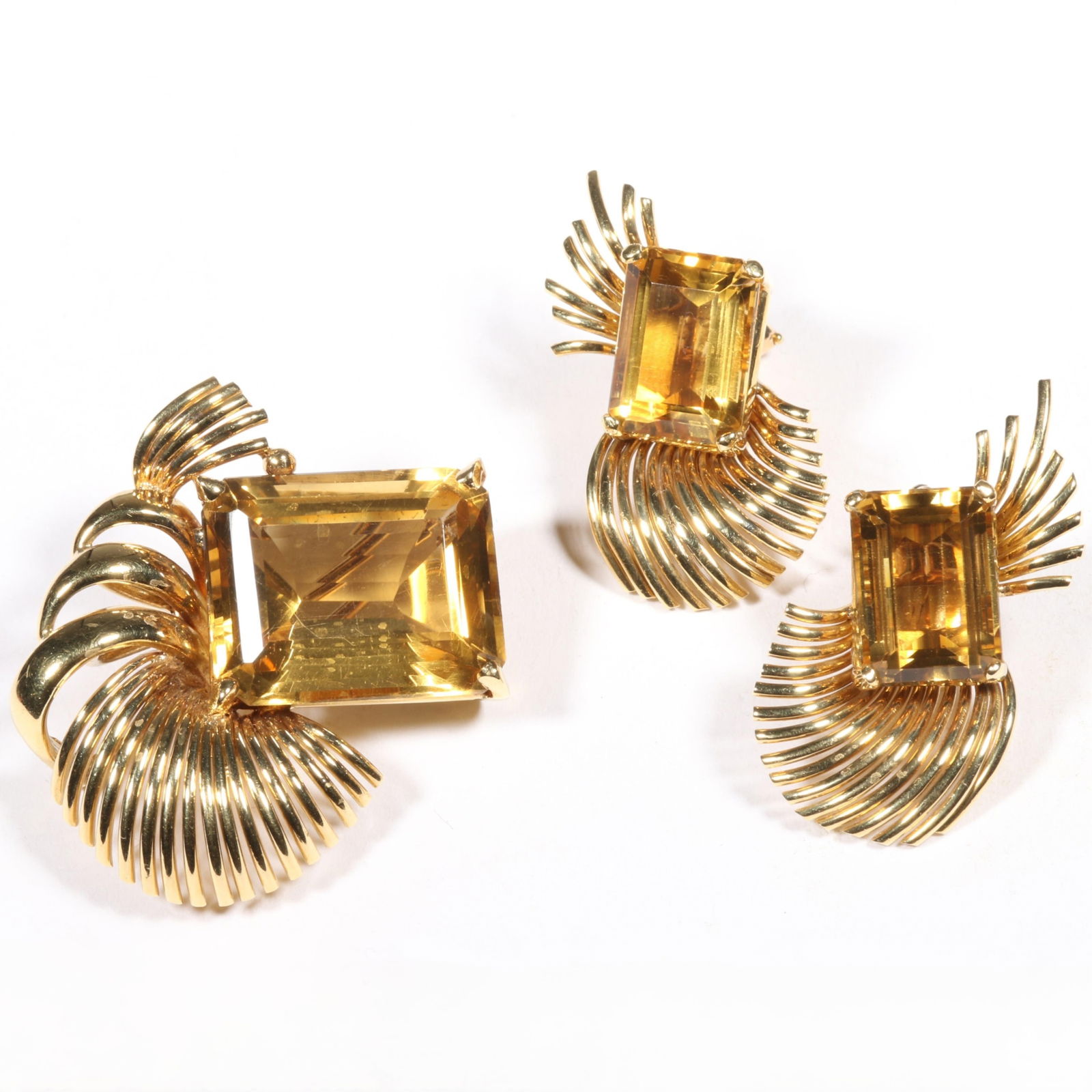 18K yellow gold Retro emerald cut citrine gemstone spray brooch with matching earrings. 1 1/4"H x 1: 18K yellow gold Retro emerald cut citrine gemstone spray brooch with matching earrings. 9.2DWT (brooch) 8.37DWT (earrings) The purchase of gold requires confirmed funds. From the collection of G. Thra