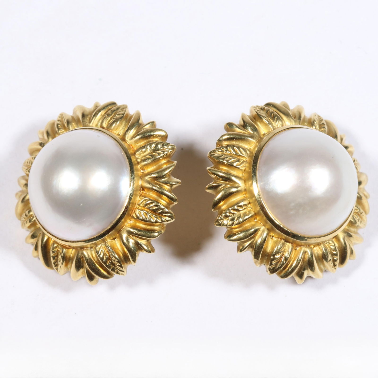 18K yellow gold floral mabe pearl clip on earrings. 1 1/8"Diameter: 18K yellow gold floral mabe pearl clip on earrings. 24.234DWT (all) 18mm pearls The purchase of gold requires confirmed funds. 1 1/8"Diameter