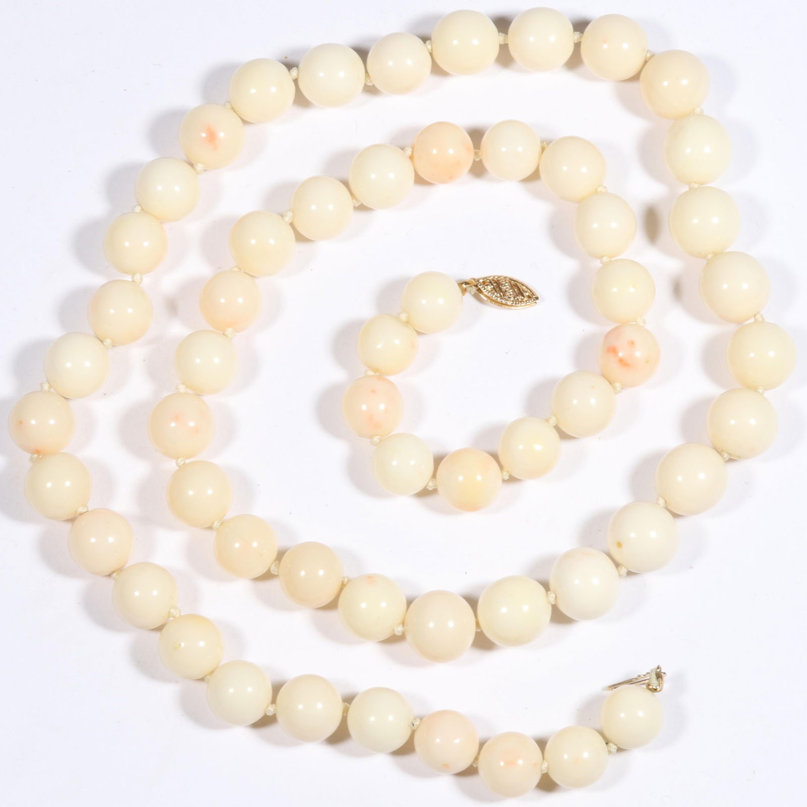 Hand knotted angel skin coral beaded necklace with 14K yellow gold clasp. 26 1/2"Long: Hand knotted angel skin coral beaded necklace with 14K yellow gold clasp. 10.1mm beads 103.4g total weight 26 1/2"Long