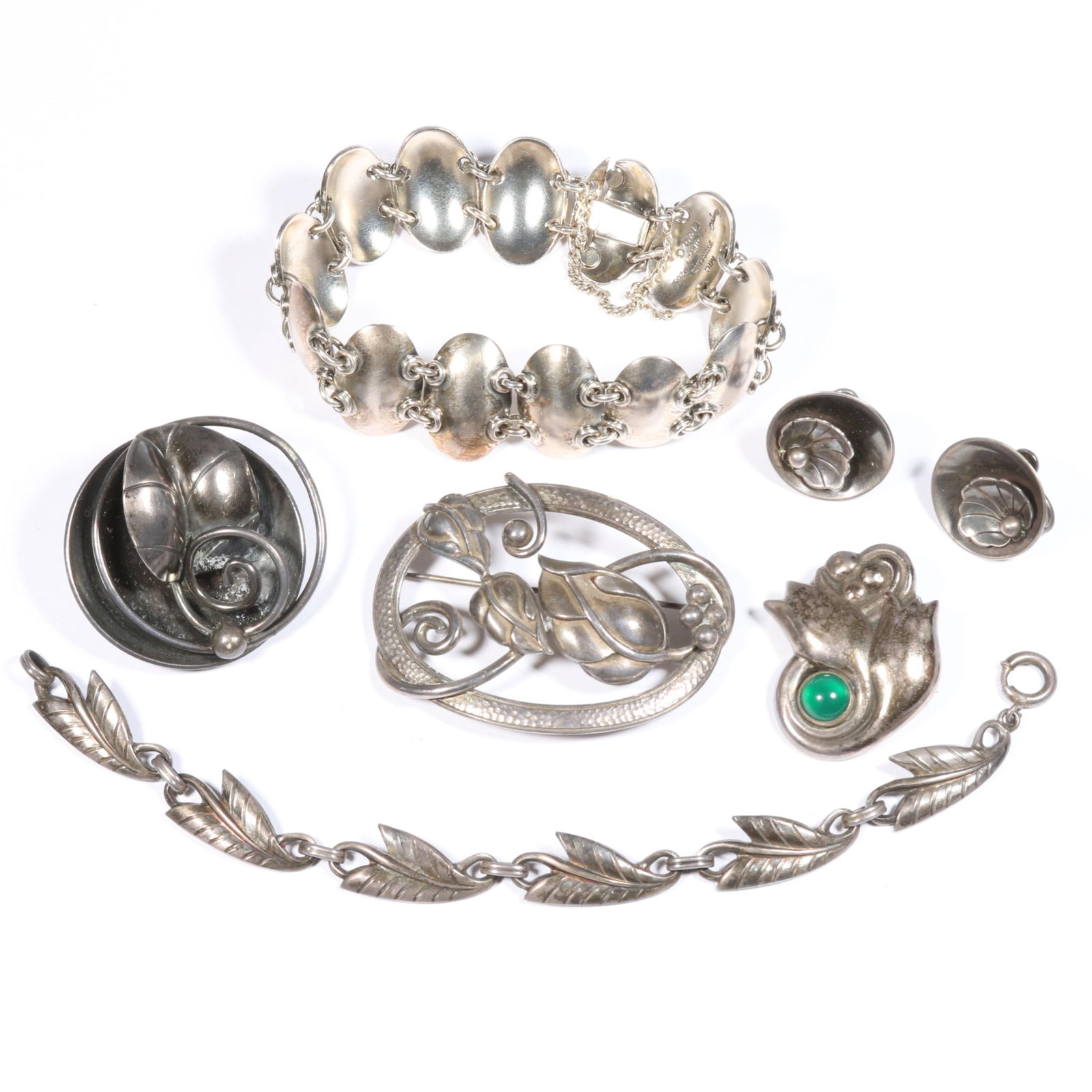 Georg Jensen floral earrings, Gertrude Engel thumbnail bracelet, Joseph Masaniello leaf brooch,: Georg Jensen floral earrings, Gertrude Engel thumbnail bracelet, Joseph Masaniello leaf brooch, included in sterling silver Danish modernist jewelry group. Some sterling is tarnished. Green cabochon b