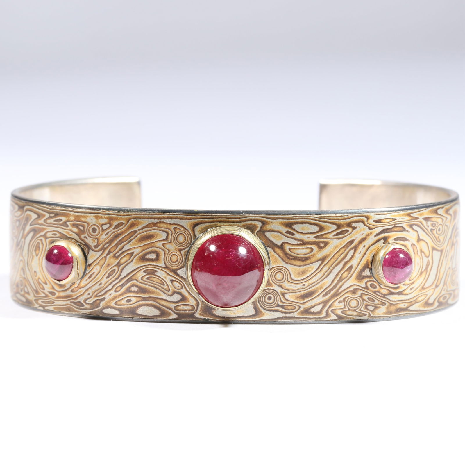 "Mokume Gane" sterling silver wood grain mixed metal and synthetic ruby cabochon extra wide cuff: "Mokume Gane" sterling silver wood grain mixed metal and synthetic ruby cabochon extra wide cuff bracelet. Signed "MS" [conjoined in a circle] 63.9g From the life time collection of Donna Soodalter-To