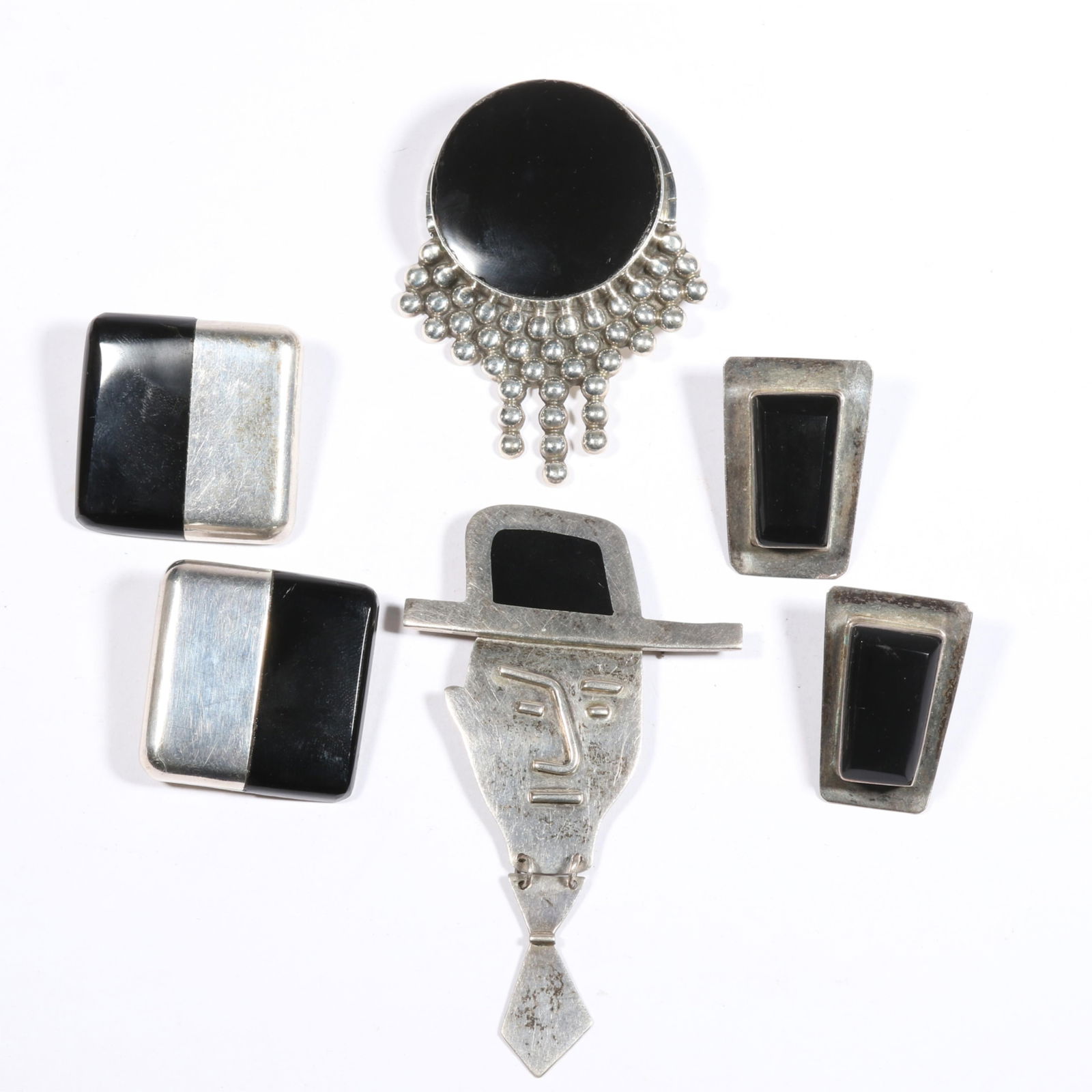 Mexican sterling silver and onyx jewelry group including Anne Harvey figural man wearing a tie: Mexican sterling silver and onyx jewelry group including Anne Harvey figural man wearing a tie brooch, Orquidea sterling onyx square earrings, large sterling bead drop brooch, and faceted onyx earring