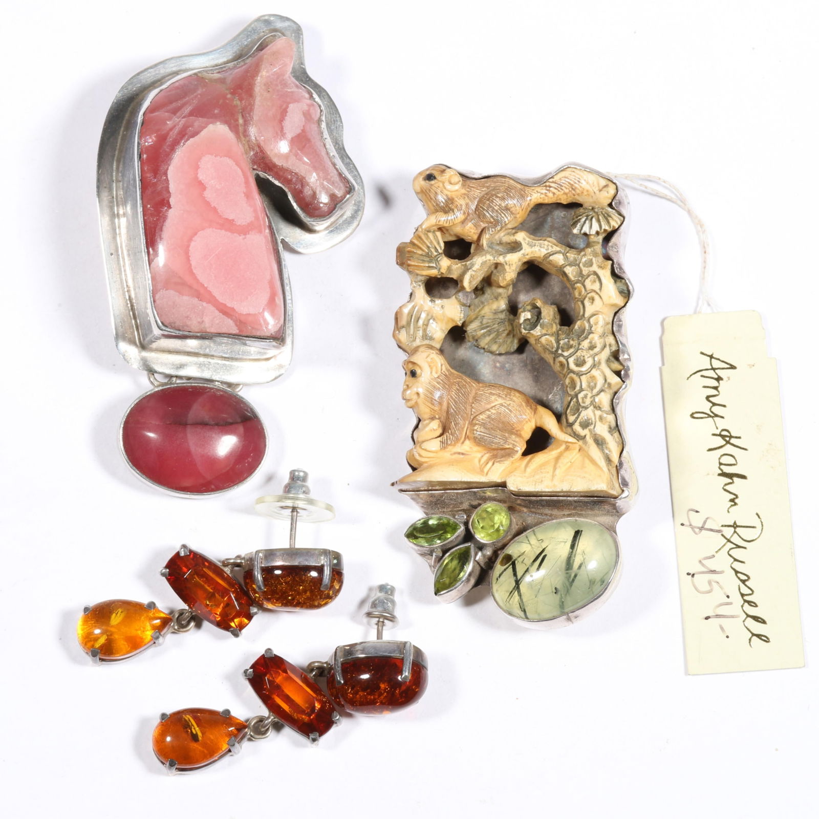 Amy Kahn Russell sterling silver jewelry group including carved Rhodochrosite horse pendant brooch,: Amy Kahn Russell sterling silver jewelry group including carved Rhodochrosite horse pendant brooch, carved fossilized bone, prehnite, and peridot pendant brooch, and Baltic amber drop earrings. Carved