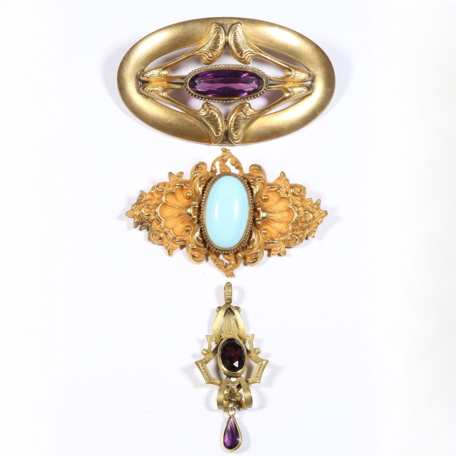 Antique Art Nouveau amethyst glass sash pin, turquoise cabochon seashell brooch, and amethyst glass: Antique Art Nouveau amethyst glass sash pin, turquoise cabochon seashell brooch, and amethyst glass jeweled pendant. 3"L x 1 5/8"W (sash pin)