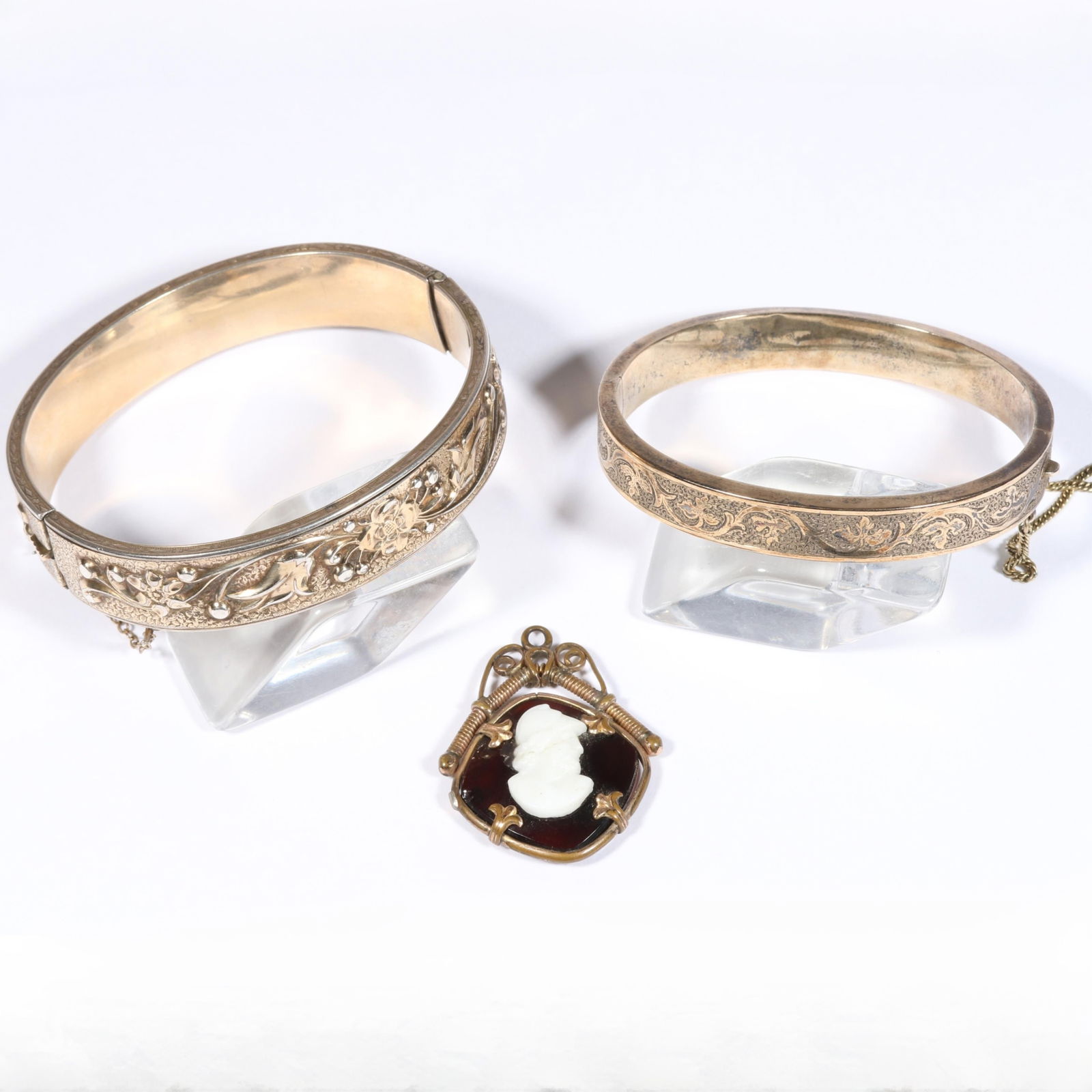 Victorian / Edwardian gold filled jewelry group including sterling vermeil large raised floral: Victorian / Edwardian gold filled jewelry group including sterling vermeil large raised floral pattern bracelet, small engraved bracelet, and Roman soldier cameo pendant. Some chips and crack through