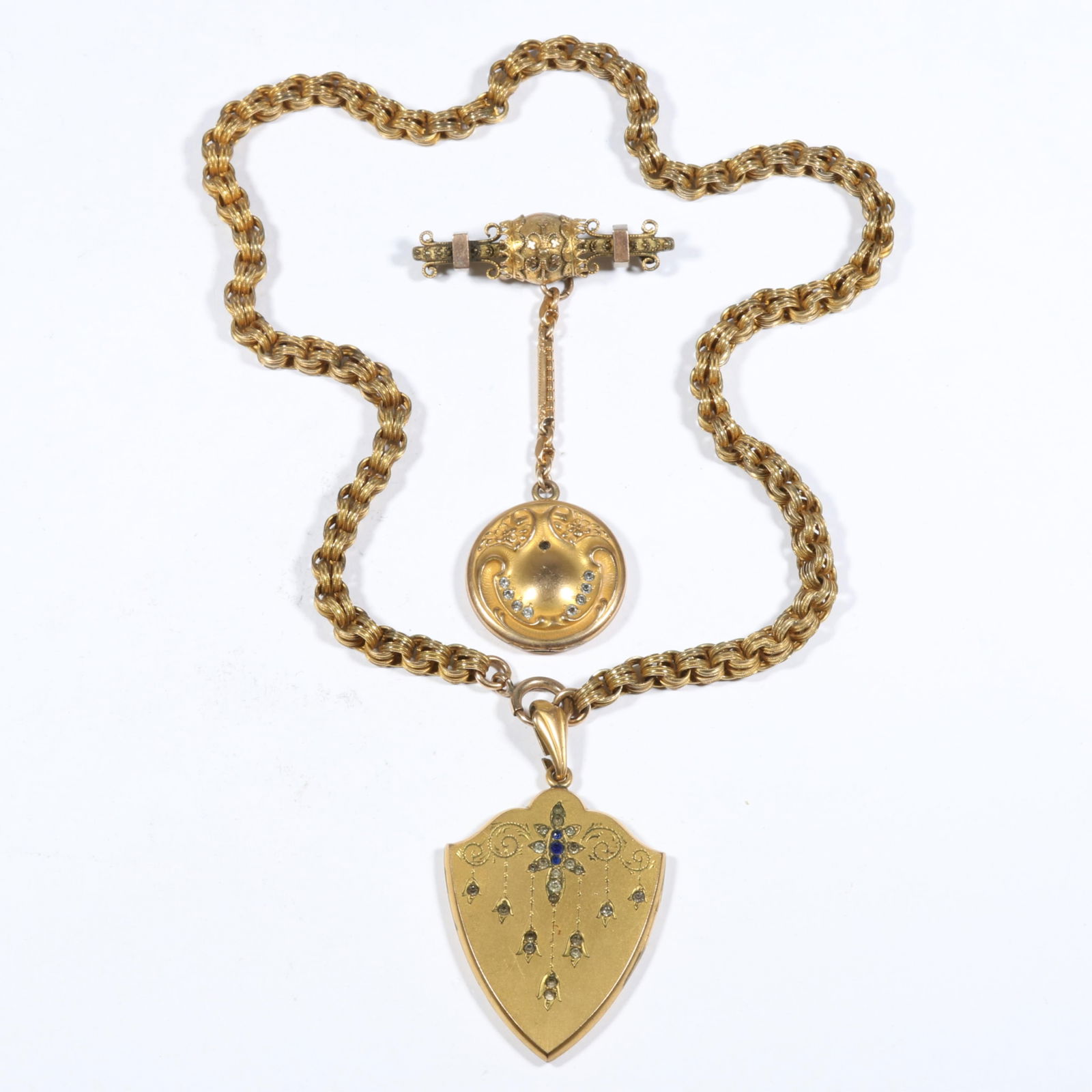 Antique Victorian jeweled shield locket necklace with paste stones and art nouveau locket on: Antique Victorian jeweled shield locket necklace with paste stones and art nouveau locket on Etruscan Revival bar brooch with gold front Provenance: From the collection of Sue Rudman, owner of Antique