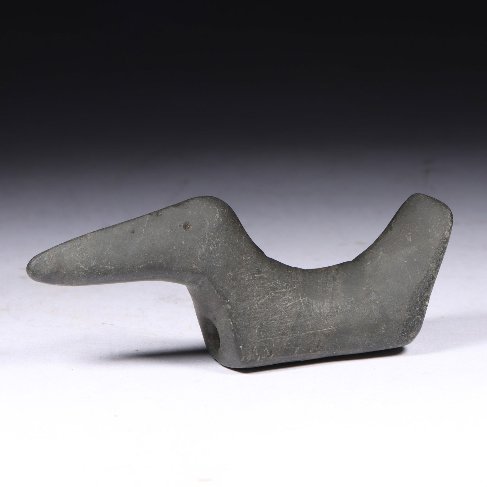 Birdstone, Slate: 3 3/4 x 1 Williams Co. Ohio: Birdstone, Slate: prehistoric artifact, Townsend Collection. Made of grey very faintly banded slate; this is an unusually styled bird with the head nearly as long as the body. It also has drilled eyes
