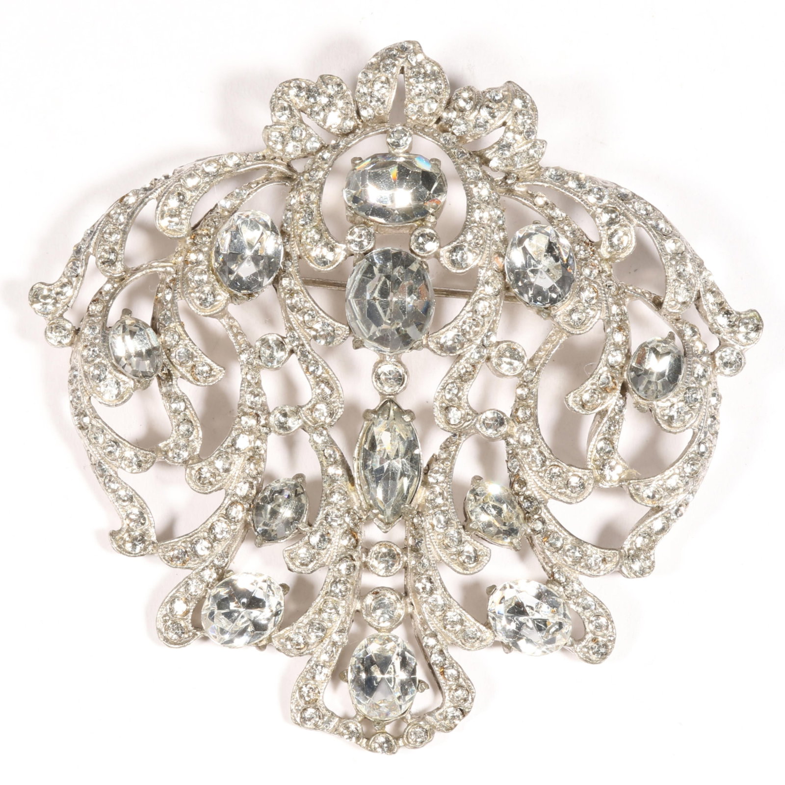 Large Staret open work shield form brooch with lines of diamante rhinestones and marquise and round: Large Staret open work shield form brooch with lines of diamante rhinestones and marquise and round faceted crystals Provenance: From the Collection of Joan Duran 3 1/4"H x 3 1/4"W