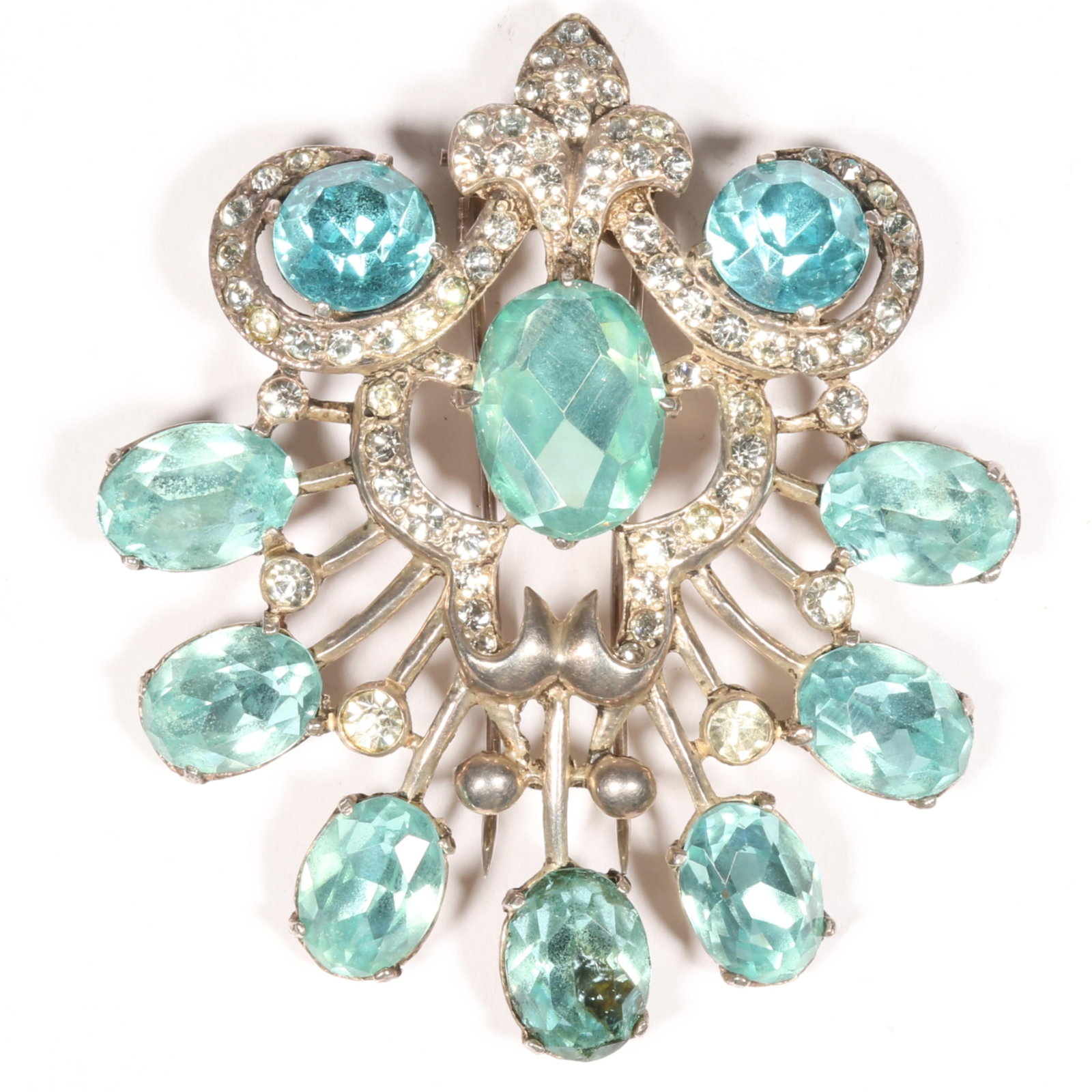 Eisenberg Original sterling silver open work fur clip with 10 large oval aqua faceted crystals,: Eisenberg Original sterling silver open work fur clip with 10 large oval aqua faceted crystals, clear bezel set rhinestones, and looping lines of pave rhinestones, mid-1940s. Dark spot in lower aqua s