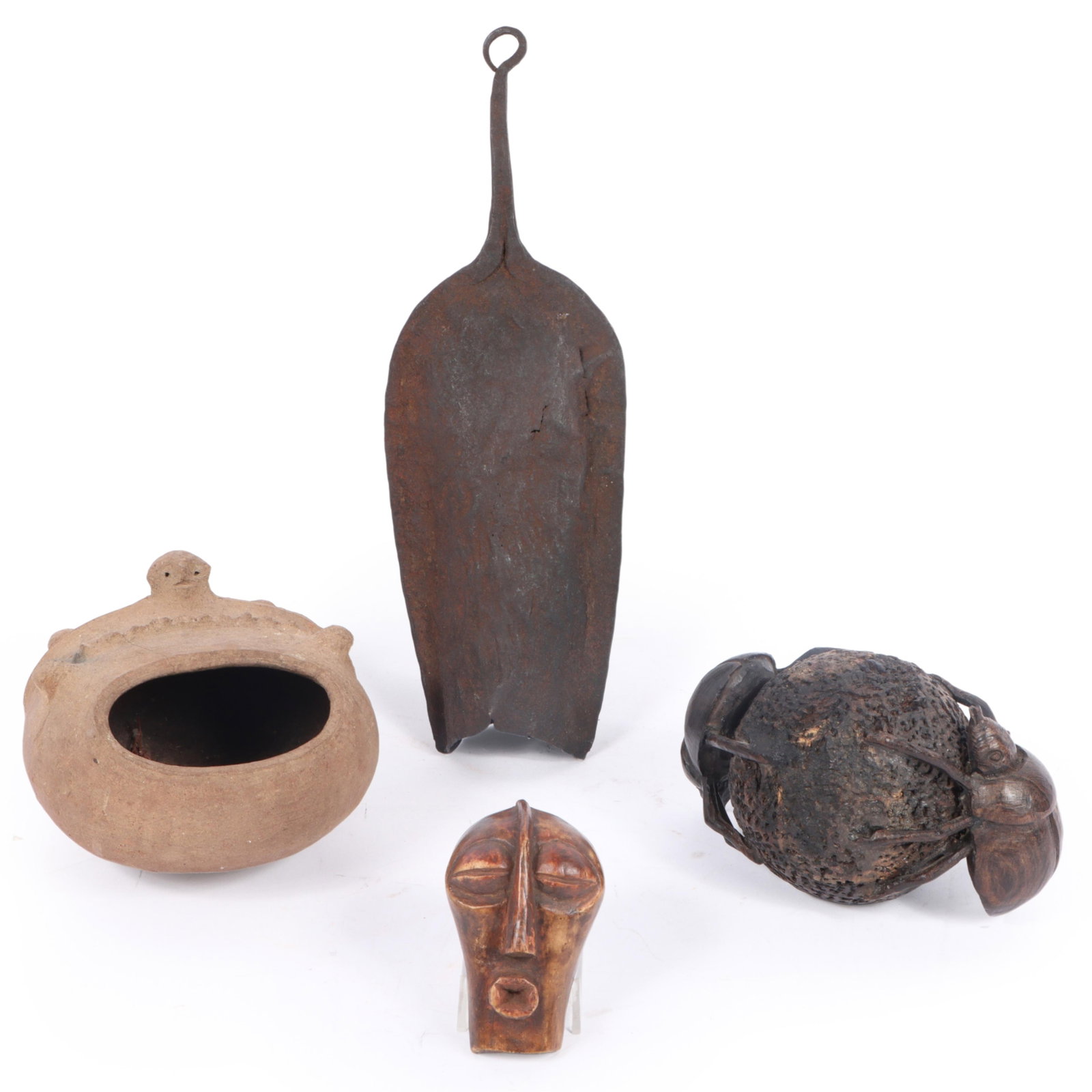 Four African tribal pieces including a metal bell, a carved dung beetle sculpture, a Nupe Igbo clay (1 of 13)