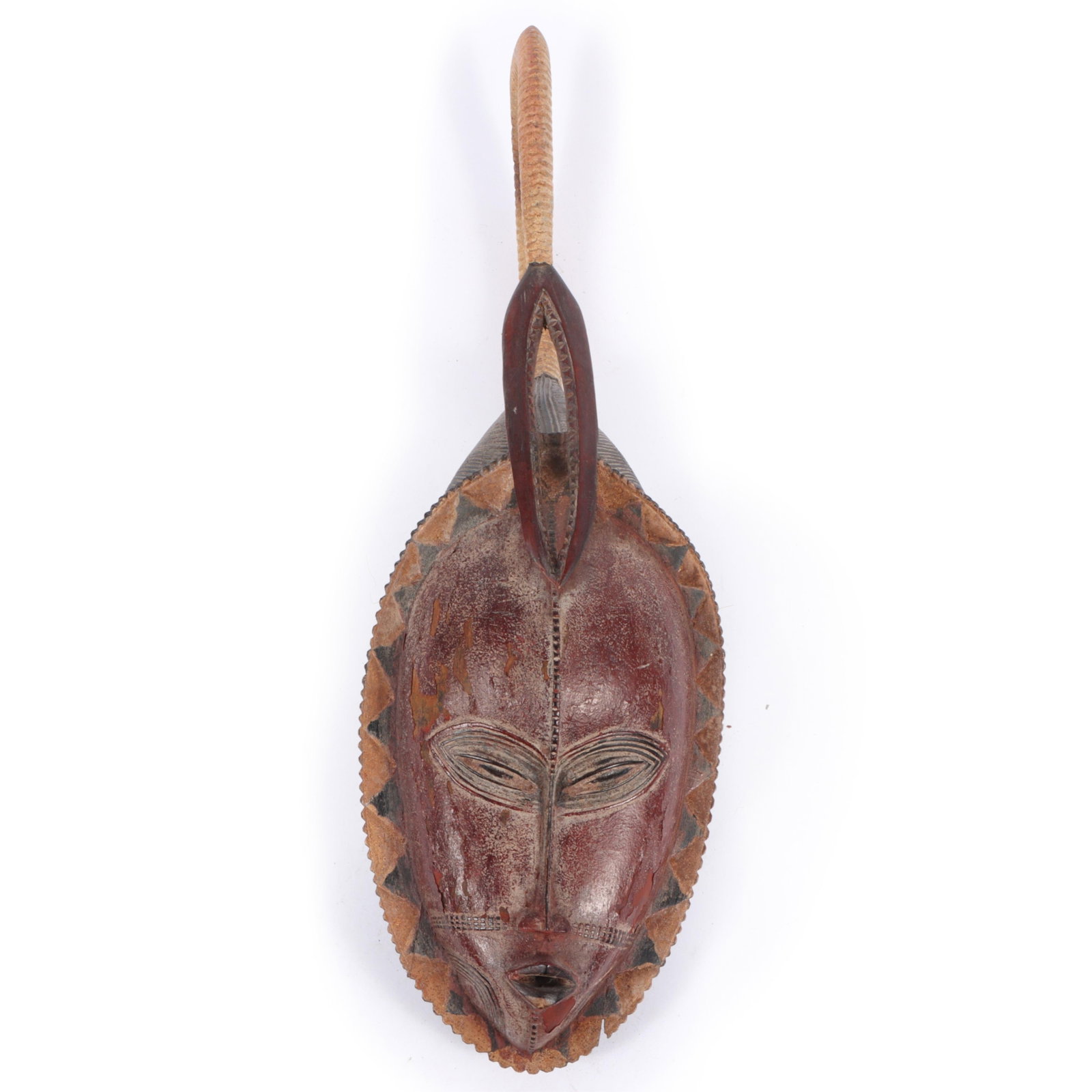 African carved polychrome ceremonial tribal wood spirit mask, Guro or Baule people of the Ivory: African carved polychrome ceremonial tribal wood spirit mask, Guro or Baule people of the Ivory Coast.? A traditional tribal mask featuring intricate carvings and a prominent loop at the top. The mask