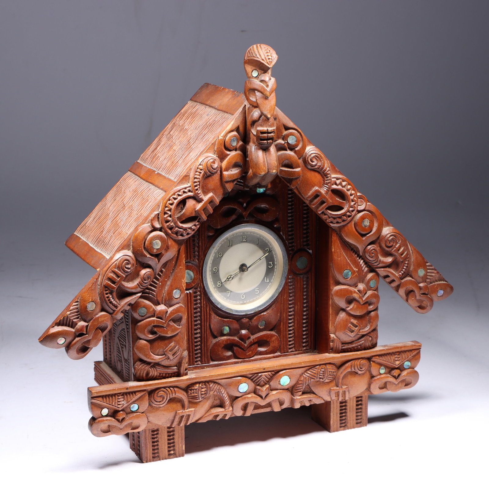 Vintage Maori meeting house style carved wood mantel clock with totem tiki figures and inlaid paua: Vintage Maori meeting house style carved wood mantel clock with totem tiki figures and inlaid paua shell, New Zealand. 12 1/2"H x 13 1/2"W