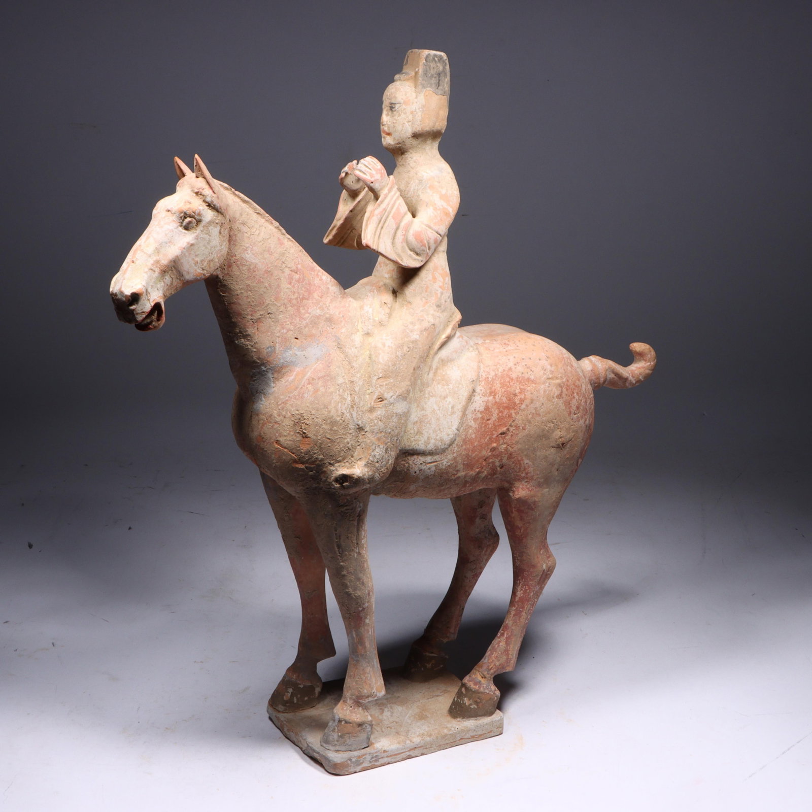Chinese Tang Dynasty painted terrecotta pottery equestrian musician figure on horse standing: Chinese Tang Dynasty painted terrecotta pottery equestrian musician figure on horse standing foursquare on a plinth with head turned slightly. Traces of original pigment. 17 1/2"H x 5 1/2"W x 15 1/2"D