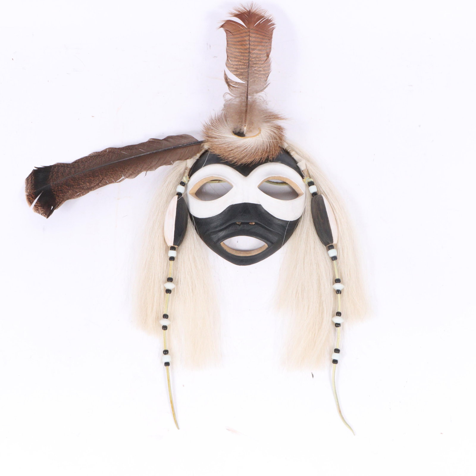 Gerard Tsonakwa (b. 1943) Abenaki Native American Indigenous ?Winasoziz Bebonai? carved and painted: Gerard Tsonakwa (b. 1943) Abenaki Native American Indigenous ?Winasoziz Bebonai? carved and painted spirit mask with applied feathers, fur, horse hair, and beads, 2002 Signed and dated verso. Alphanum