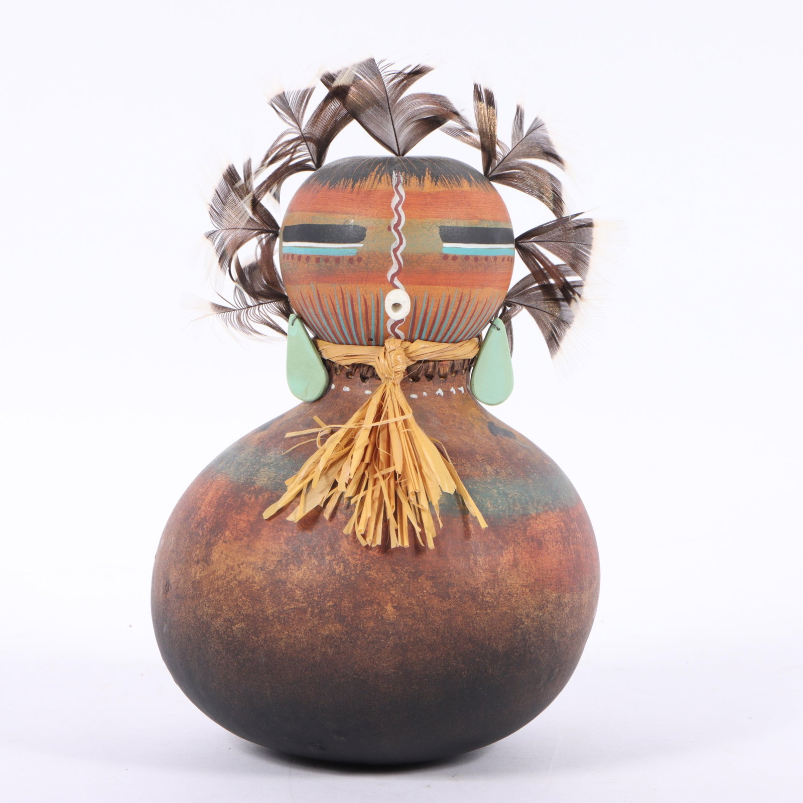 Robert Rivera (20th/21st century) Southwestern polychrome figural gourd sculpture with feathers,: Robert Rivera (20th/21st century) Southwestern polychrome figural gourd sculpture with feathers, natural stone earrings, and raffia neck tie, 1992 Signed and dated under base. Provenance: purchased 7/