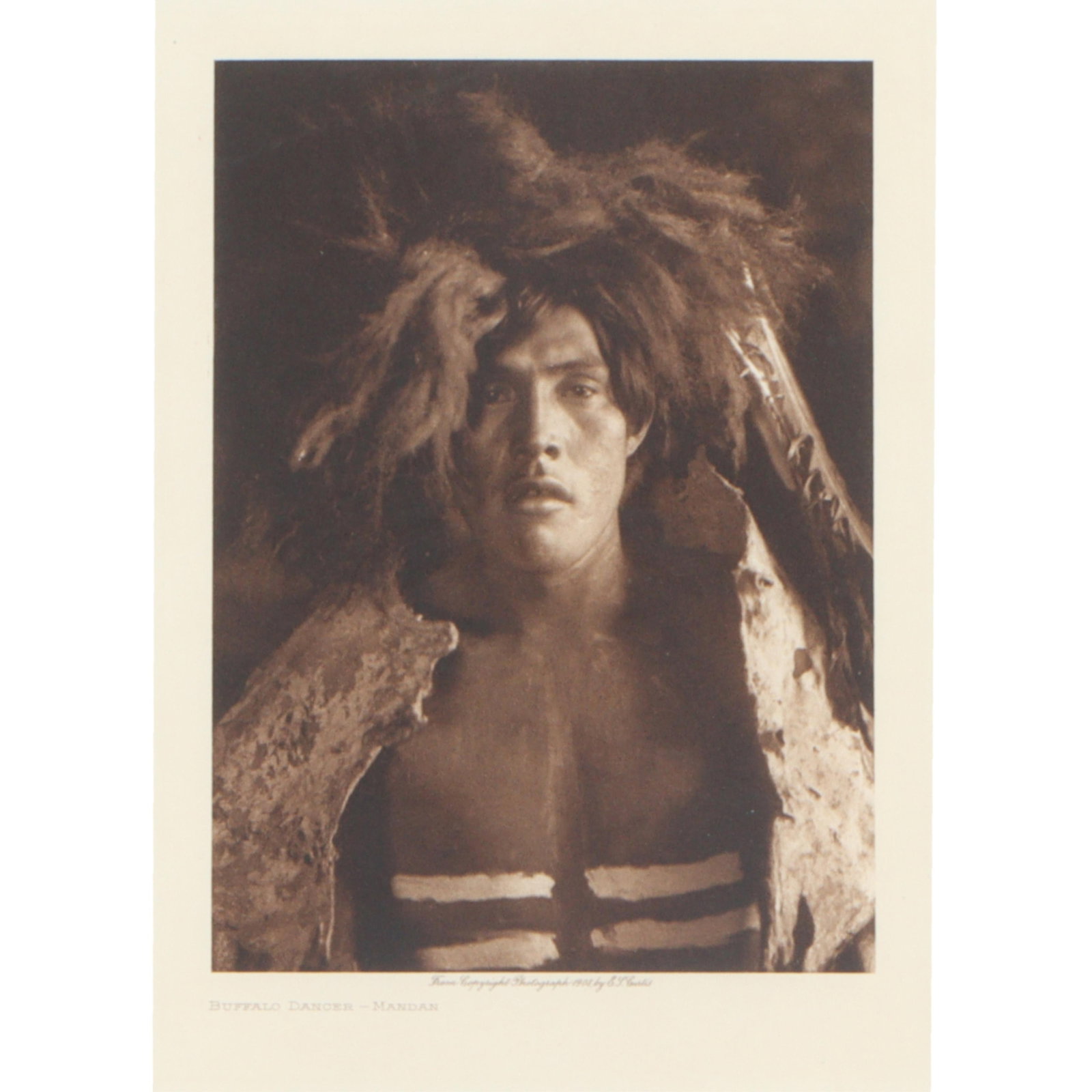 Edward S Curtis, American (1868–1952), Buffalo Dancer - Mandan, Photogravure, 9"H x 6: 18"H x 14 3/4"W(frame)Description:Edward S CurtisAmerican, (1868–1952)Buffalo Dancer - MandanPhotogravureFramed photo of an original photogravure titled "Buffalo Dancer - Mandan" by photographer Edw